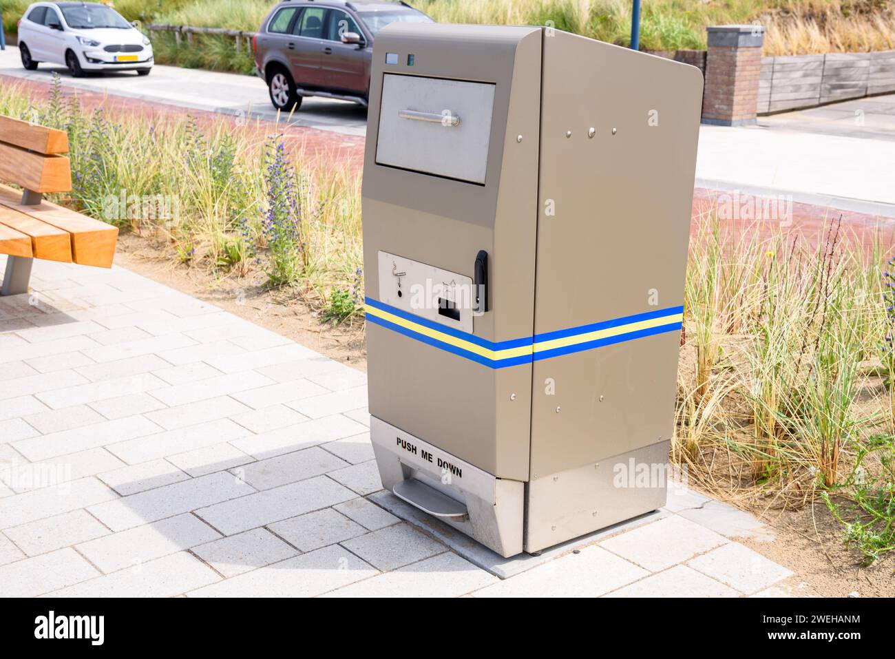 Mülltonne auf einem gepflasterten Weg an einem sonnigen Sommertag Stockfoto