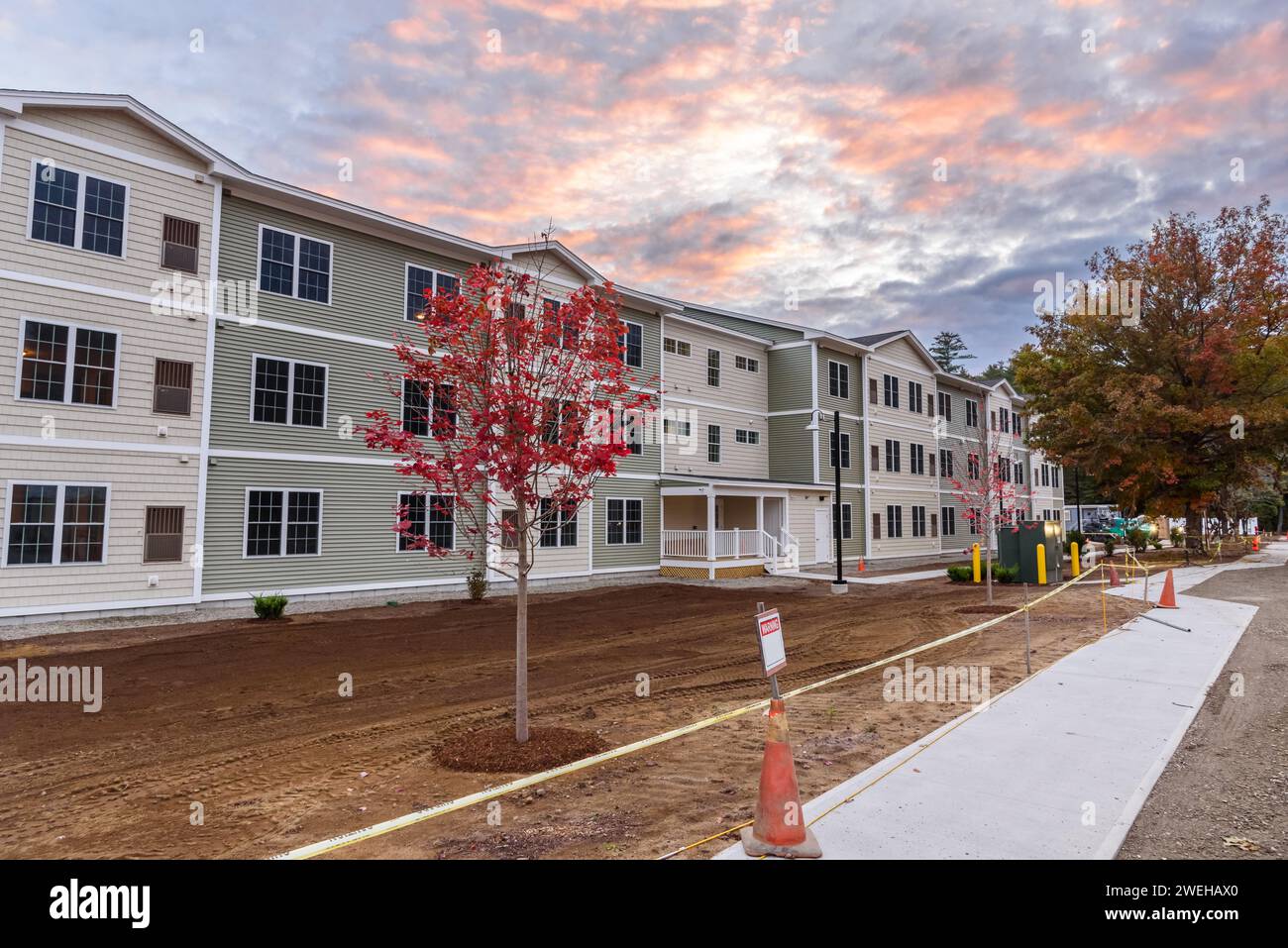 Exetrior eines Apartmentgebäudes im Bau in einer Vorstadtentwicklung unter dramatischem Himmel bei Sonnenuntergang Stockfoto