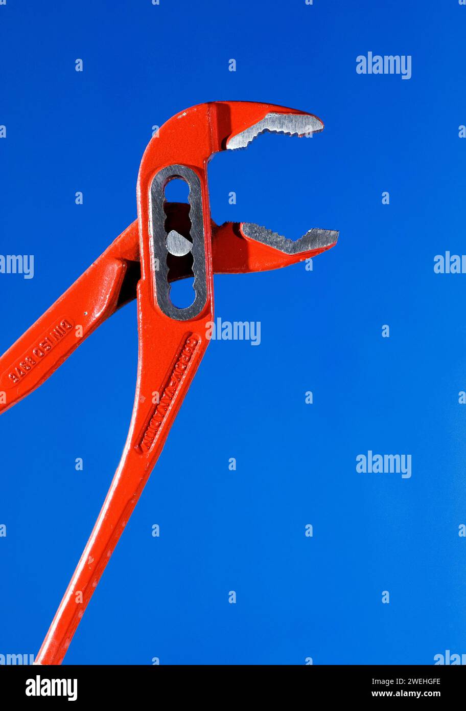 Offene, geöffnete rote Zange mit Feder und Nut, Nahaufnahme vor blauem Hintergrund Stockfoto