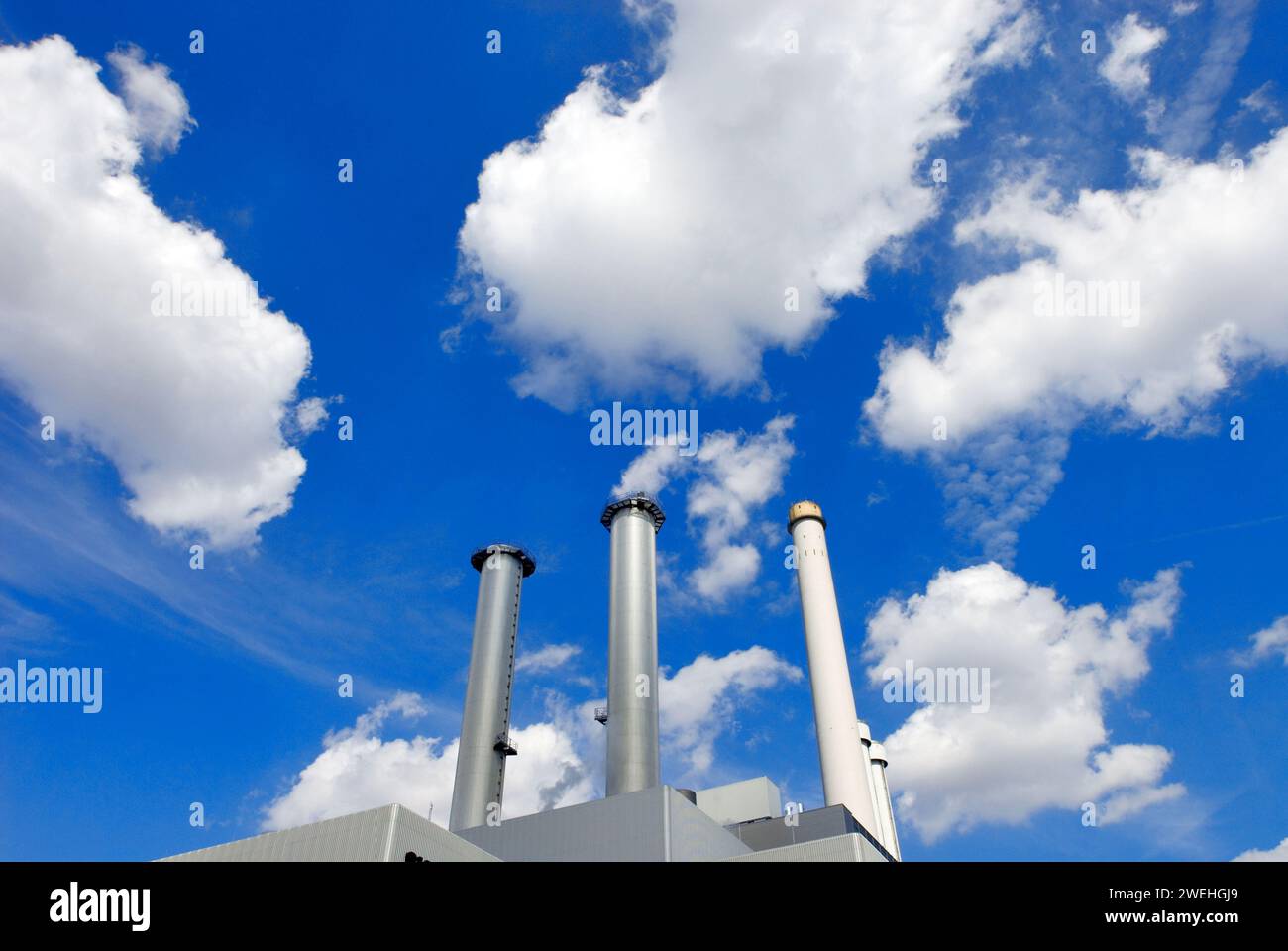 Kraft-Wärme-Kopplungsanlage südlich mit weißen Wolken am blauen Himmel, München, Bayern, Deutschland, Europa, Symbol für saubere Luft Stockfoto