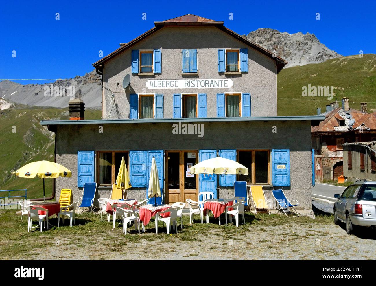 Ein leeres, verblasstes Albergo Restaurant in der Nähe des Stilfserpasses mit Sonnenschirmen und Tischen draußen, aber keine Gäste, Südtirol, Italien, Europa Stockfoto