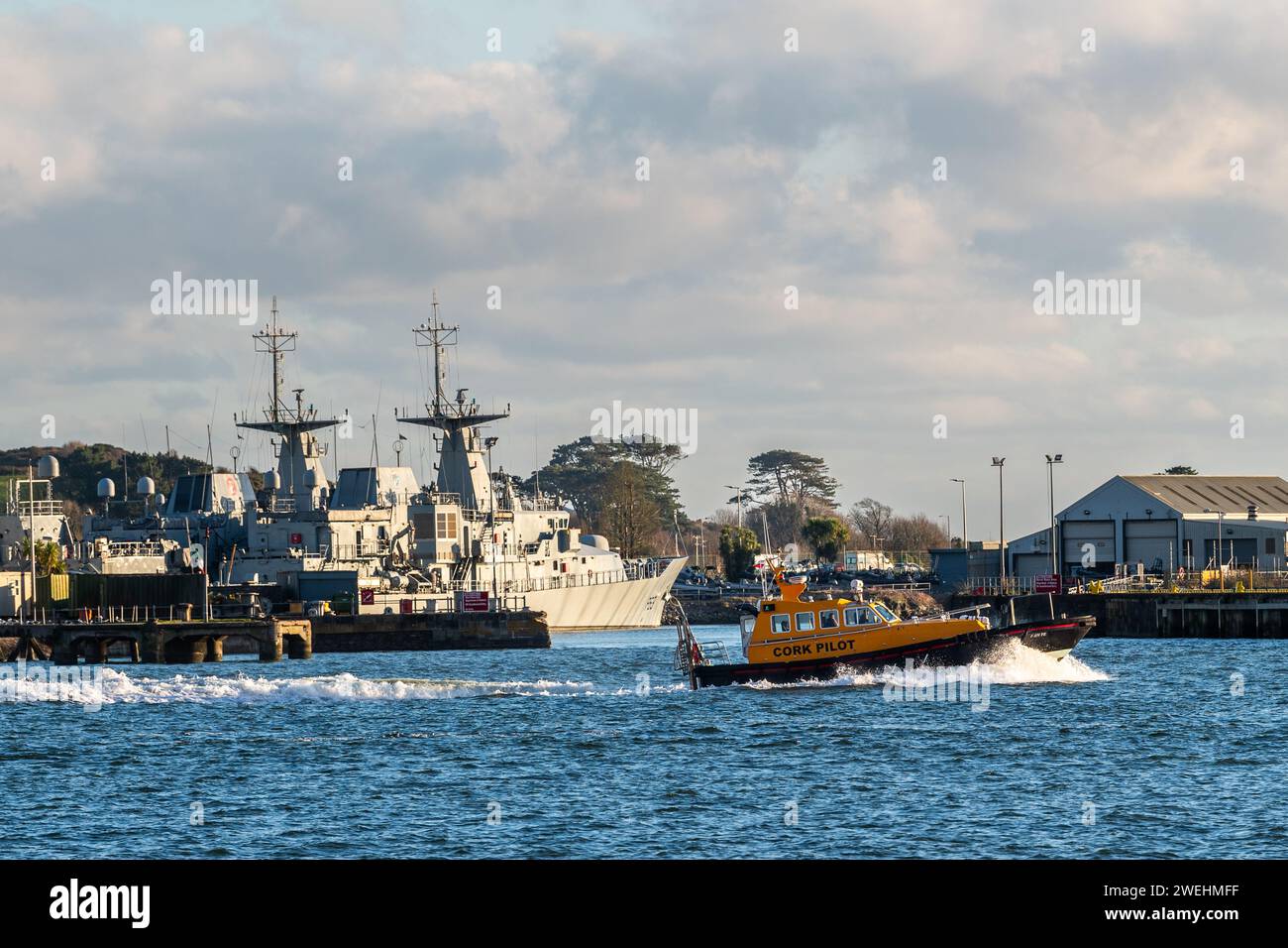 Das Cork-Pilot-Boot „Fáilte“ fährt an vertäuten Kriegsschiffen auf der Haulbowline Navy Base in Cobh, Co. Cork, Irland. Stockfoto