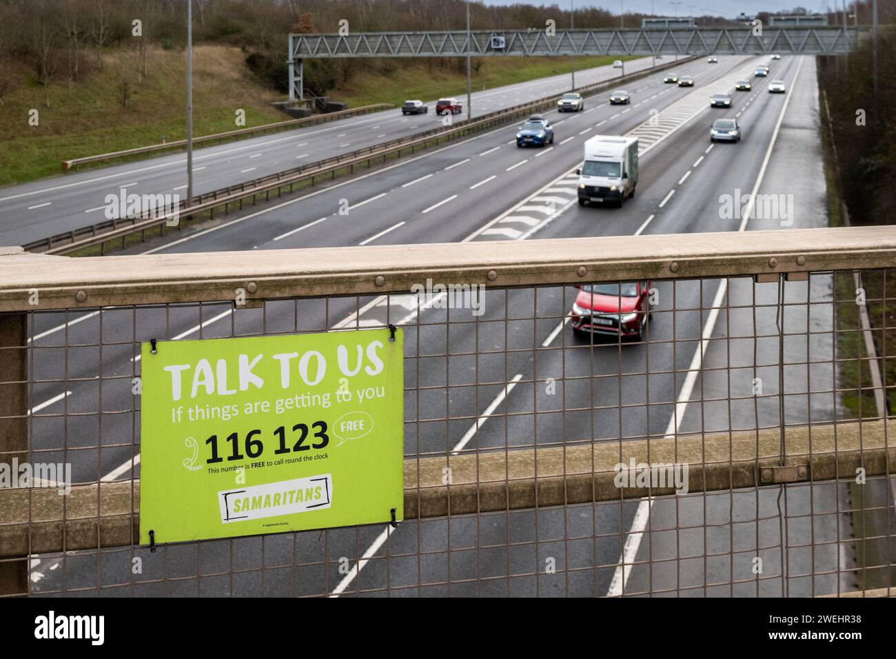 Samaritans Selbstmord-Hilfsorganisation „Talk to US“ Schild auf einer Brücke über die Autobahn M6, in der Nähe von Birmingham, Großbritannien. Stockfoto