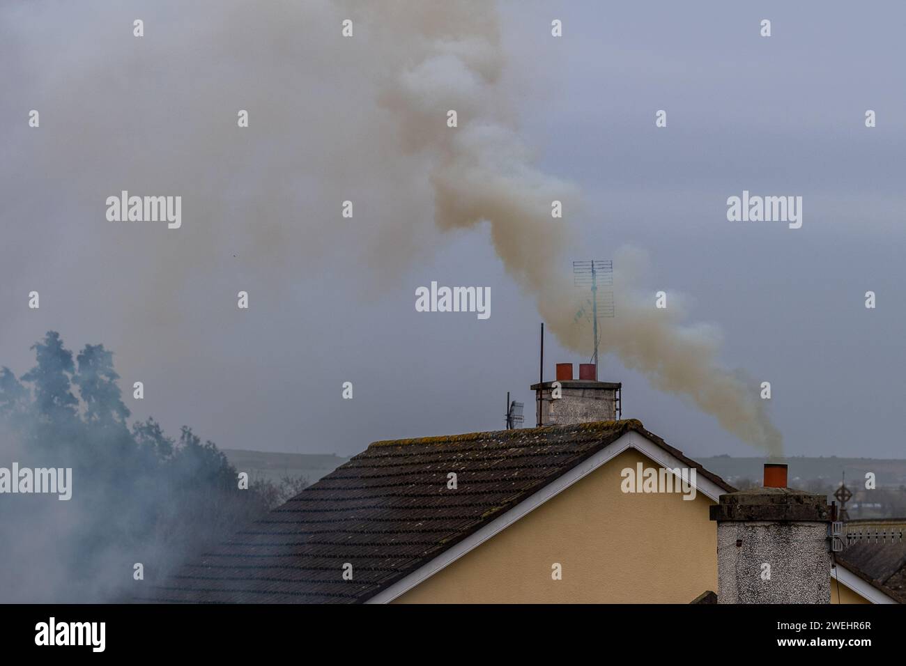 Rauch steigt aus einem Hausschornstein in Irland auf Stockfoto