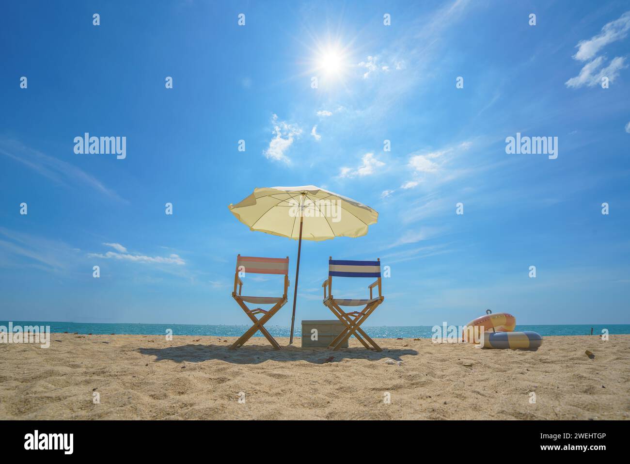 Sessel und Sonnenschirm, perfekt an einem ruhigen Strand gelegen, laden zum Entspannen ein, um die Essenz der Ruhe am Meer und das Versprechen einer friedlichen Esca einzufangen Stockfoto