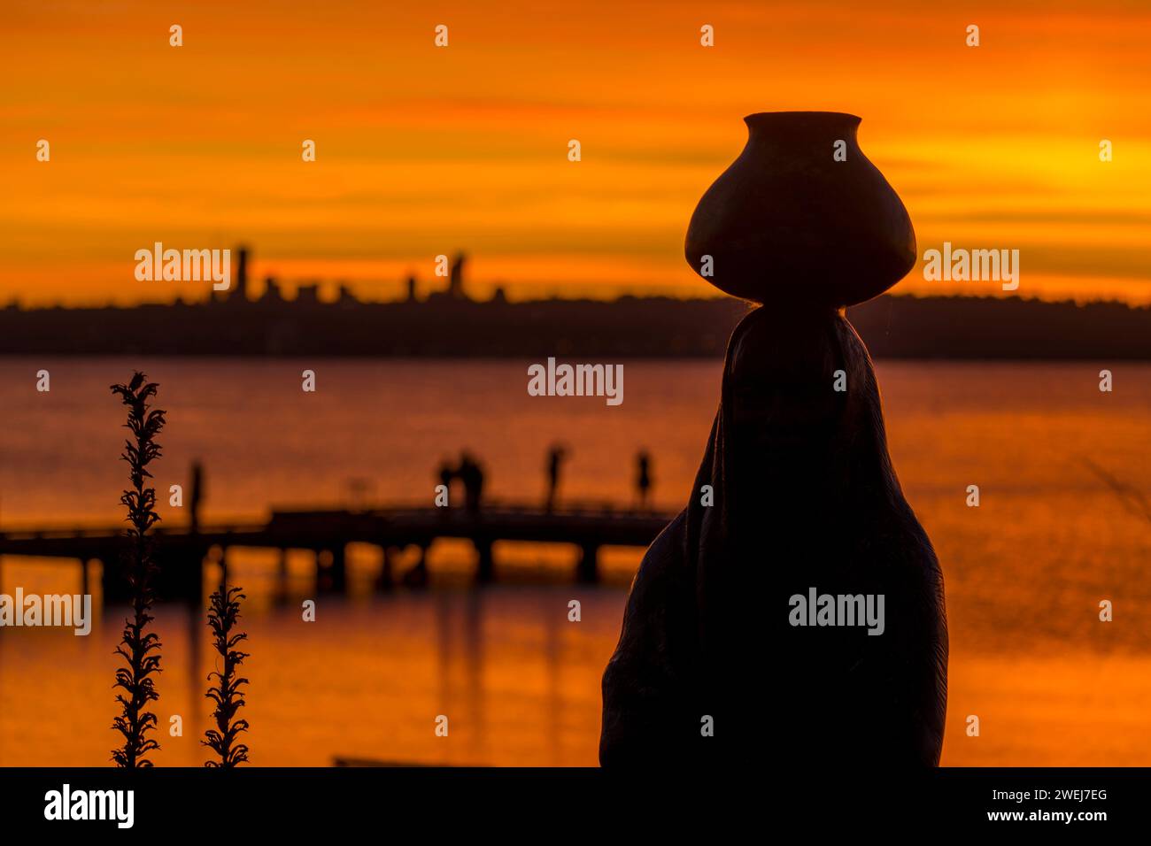 Eine Bronzestatue eines Wasserträgers von Glenna Goodacre, die bei Sonnenuntergang im David E. Brink Park am Lake Washington in Kirkland, Washington State, dargestellt wurde Stockfoto