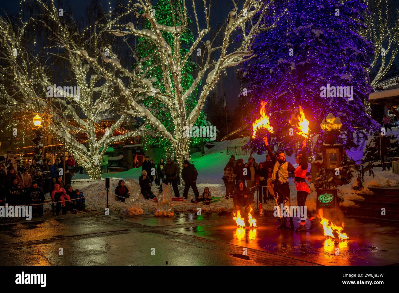 Eine Feuertanz-Aufführung des Cirque Cadia, einer Gruppe von Zirkuskünstlern, im Rahmen des Winterkarnevals unter den bunten beleuchteten Bäumen in Leavenworth, Che Stockfoto