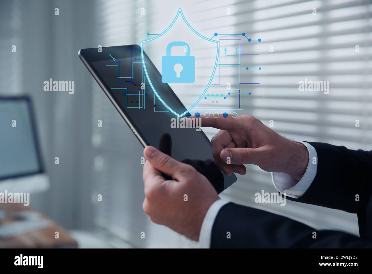 Datenschutz. Mann mit Tablet im Büro, Nahaufnahme. Digitales Schema mit Abbildung einer Abschirmung mit Vorhängeschloss über dem Gerät Stockfoto
