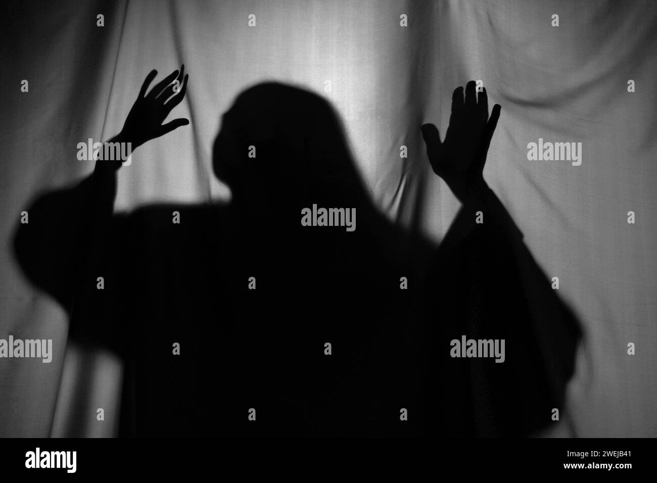 Silhouette eines gruseligen Geistes hinter grauem Tuch Stockfoto