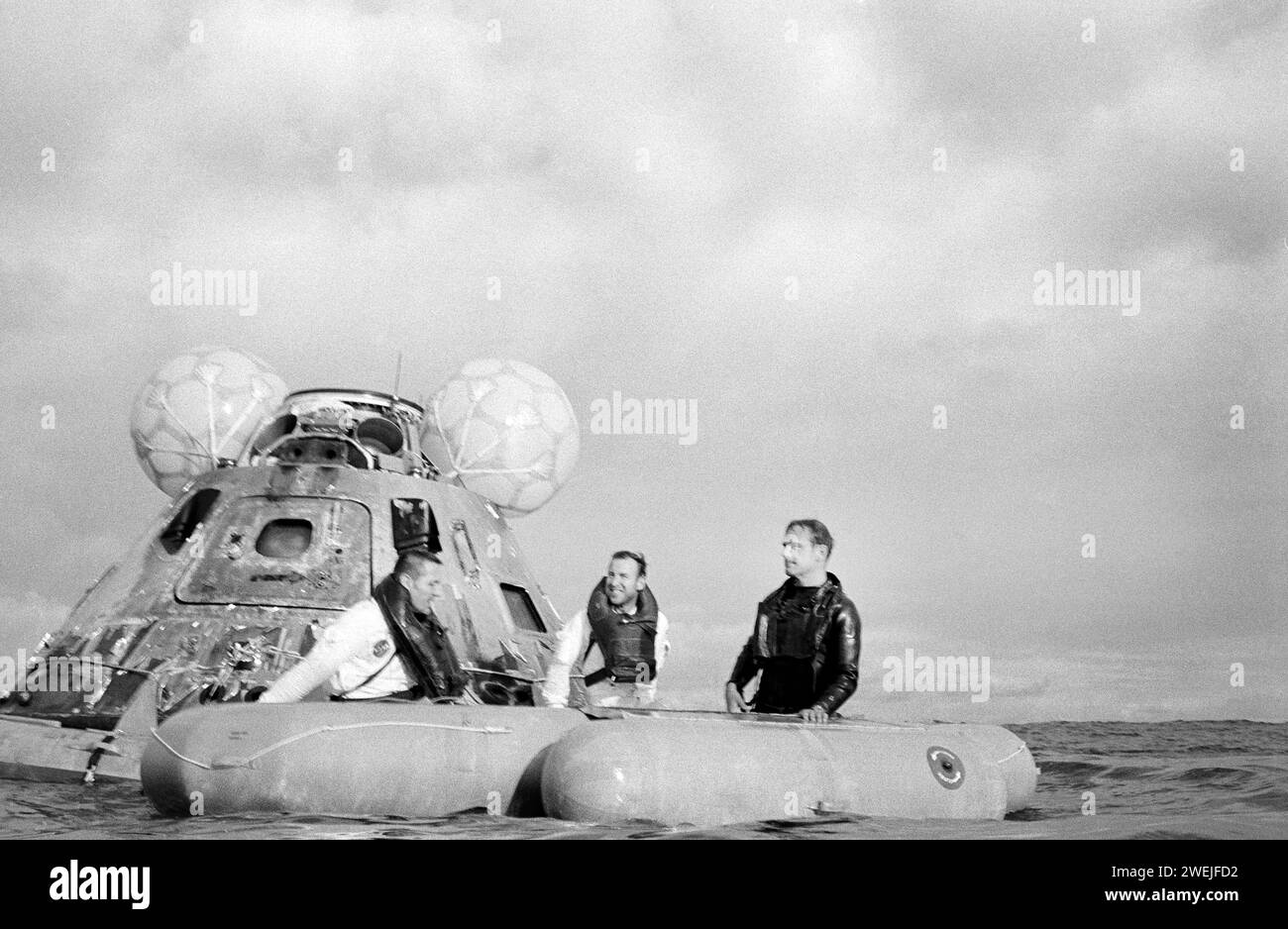 Die US-amerikanischen Astronauten James A. Lovell Jr. (Mitte), Commander, und John L. Swigert Jr. (links), Pilot des Kommandomoduls, an Bord eines Wasserfahrzeugs während der Apollo-13-Bergungsoperationen im Südpazifik, NASA, 17. April 1970 Stockfoto