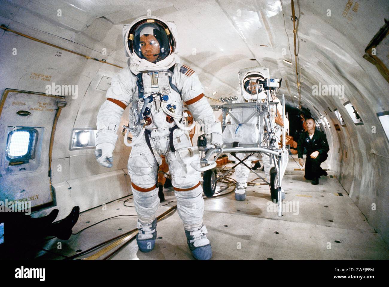 Astronaut Alan B. Shepard Jr., Kommandeur Apollo 14, der während des Trainings an Bord der Air Force KC-135 einen modularen Gerätetransporter unter schwerelosen Bedingungen zieht, mit Astronaut Edgar D. Mitchell, Pilot des Mondmoduls, im Hintergrund, Patrick Air Force Base, Brevard County, Florida, USA, NASA, November 1970 Stockfoto