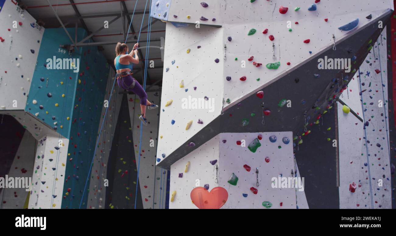 Kaukasische Frauen, die im Fitnessstudio an der Wand klettern Stockfoto