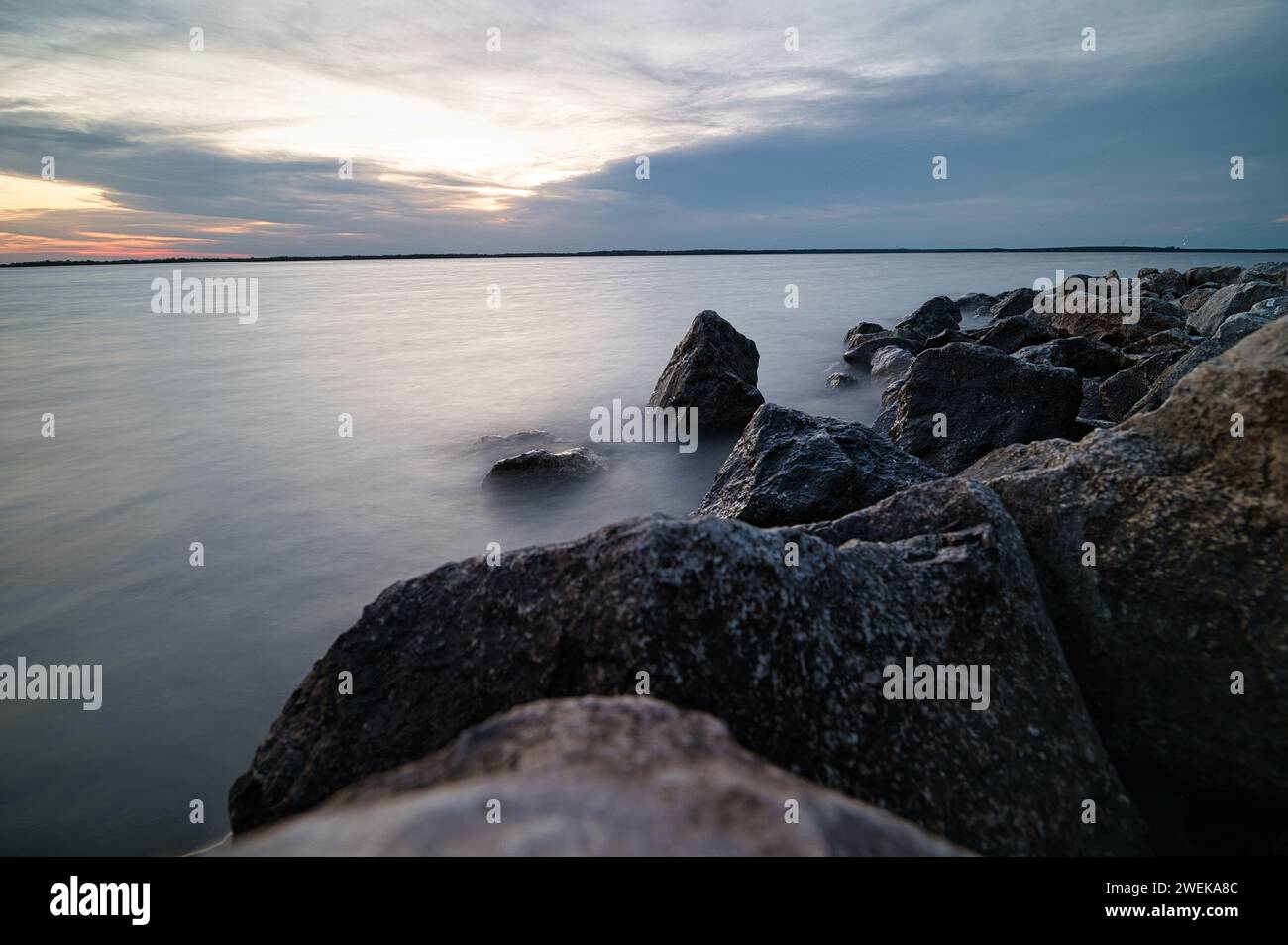 Felsen ragen entlang der Uferpromenade hervor Stockfoto