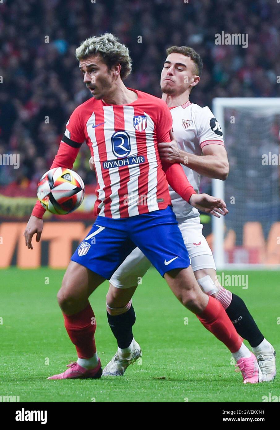 Madrid. Januar 2024. Antoine Griezmann (L) aus Atletico de Madrid wird von Adria Pedrosa aus Sevilla während des spanischen Königskalenspiels (Copa del Rey) zwischen Club Atletico de Madrid und Sevilla FC am 25. Januar 2024 in Madrid verteidigt. Gustavo Valiente/Xinhua/Alamy Live News Stockfoto