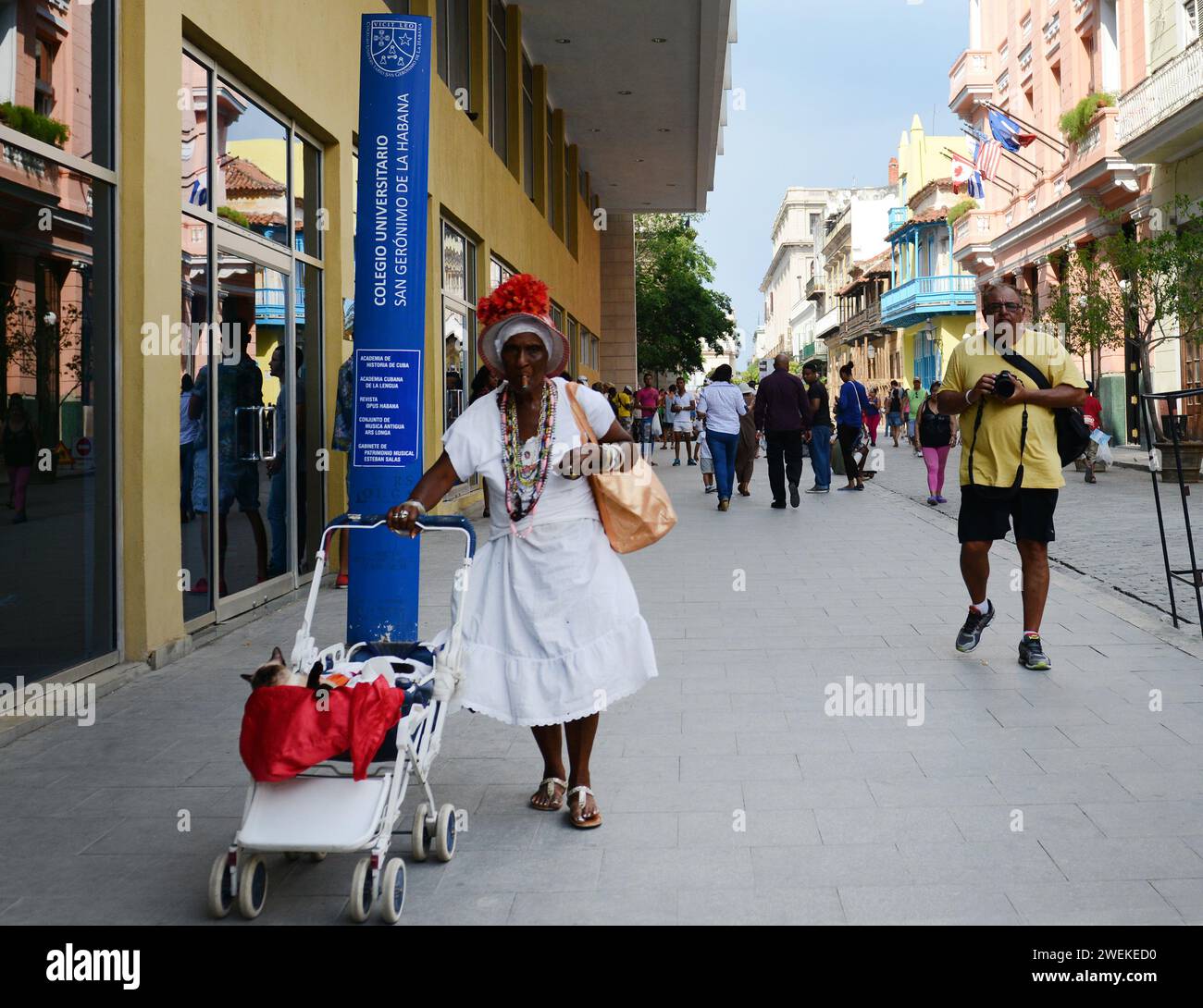 Eine traditionell gekleidete kubanische Frau, die auf einer Hauptstraße im alten Havanna, Kuba, spaziert. Stockfoto