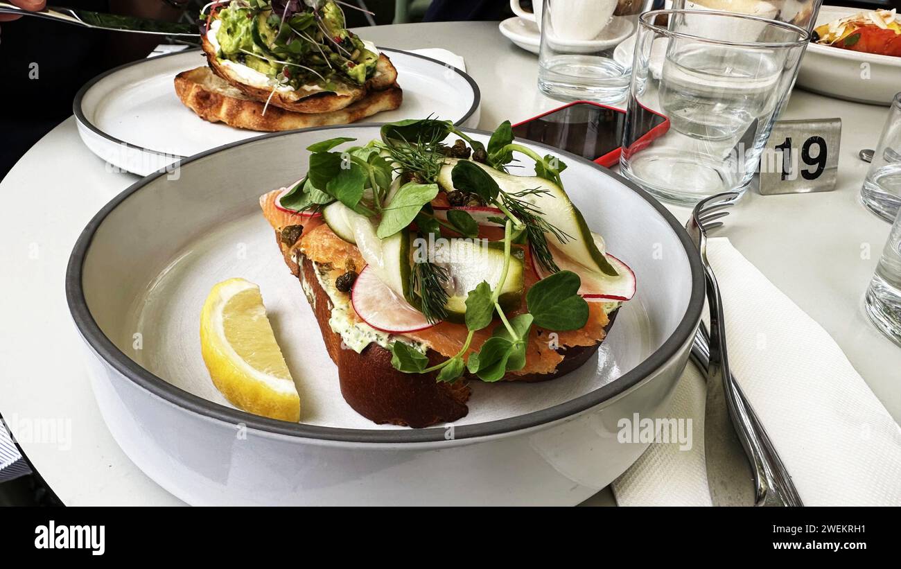 Nahaufnahme eines Sandwiches mit Lachs und Gemüse auf dem Tisch Stockfoto