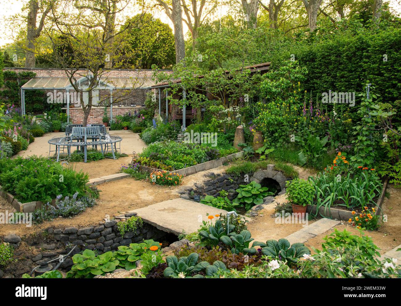 Dekorative und essbare Pflanzen in einem ummauerten Garten im Savills Garden, entworfen von Mark Gregory. Stockfoto