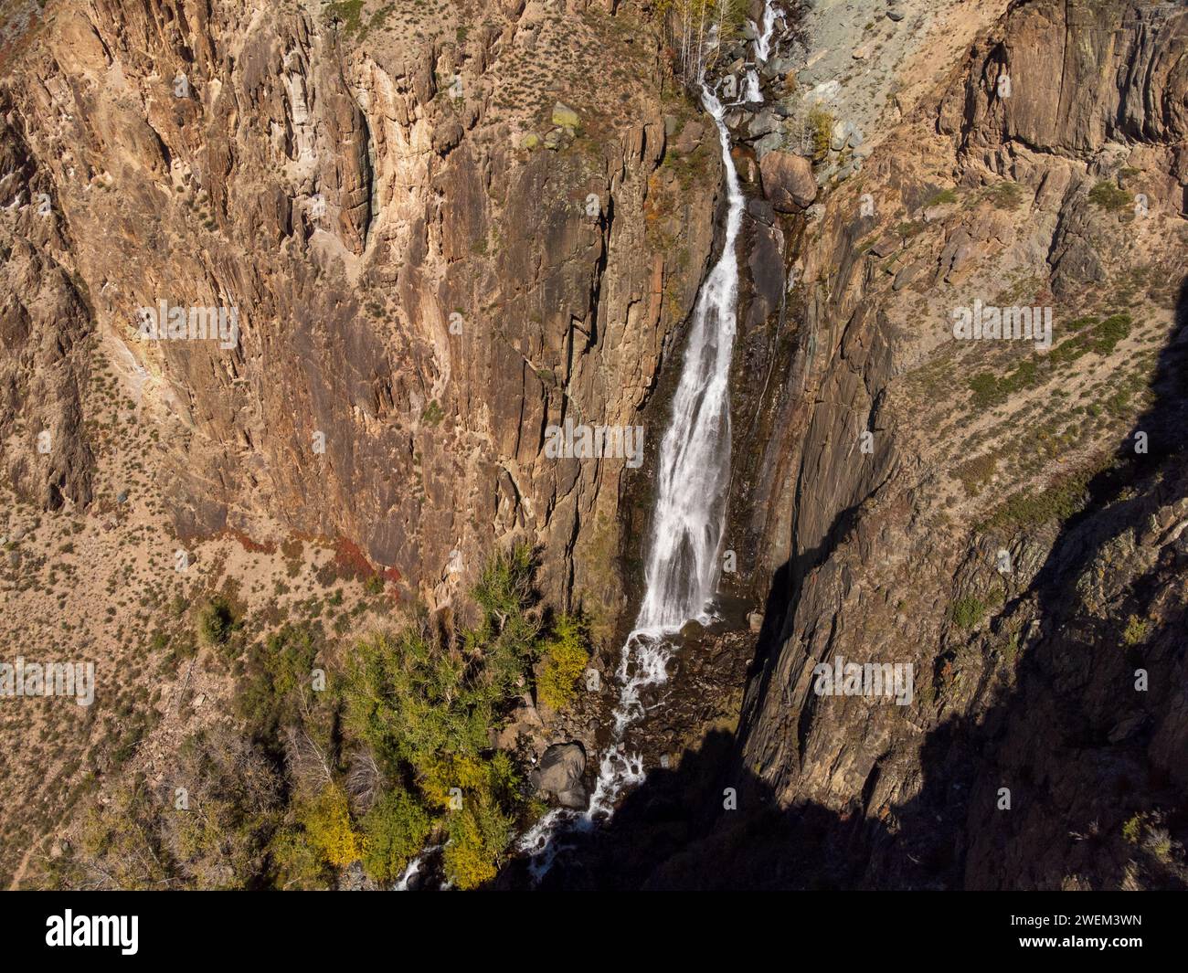 Atemberaubende Luftaufnahme eines Wasserfalls in Altai, Russland, die die Pracht der Natur inmitten zerklüfteter Landschaften zeigt. Stockfoto