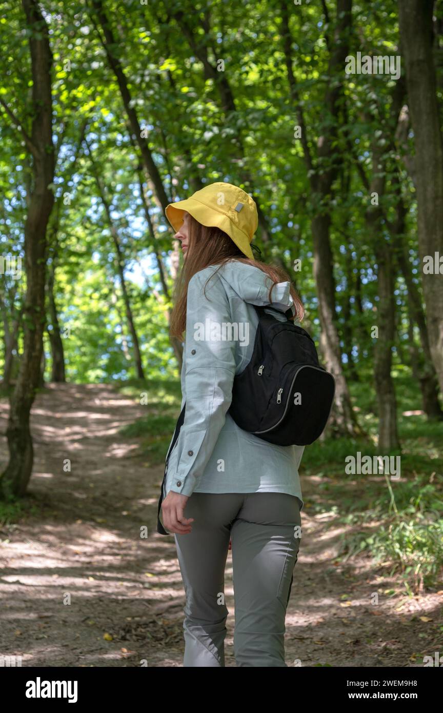 Eine junge Frau, die im tiefen grünen Wald läuft. Stockfoto