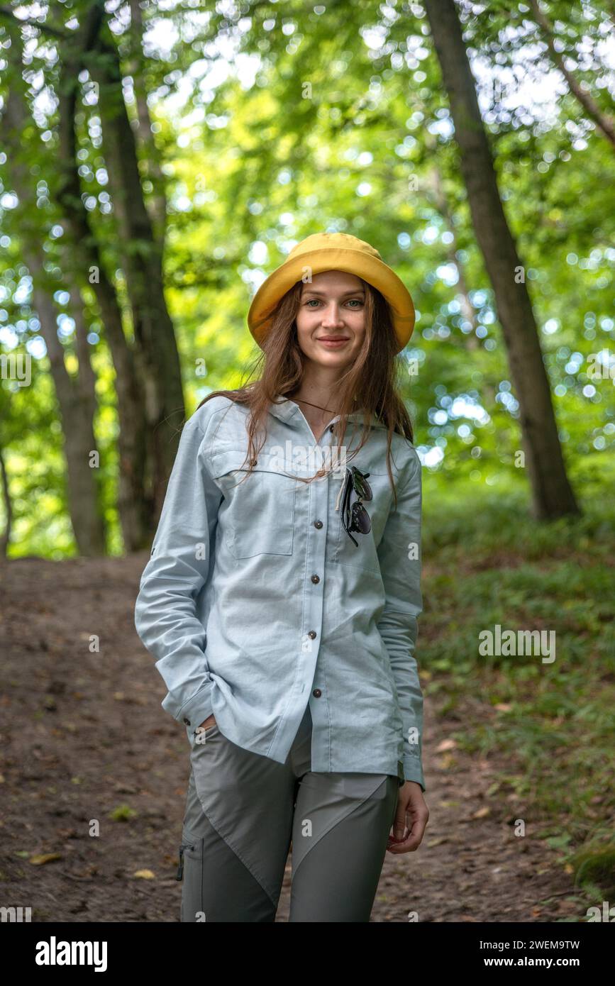 Porträt Junge Frau, die im tiefen grünen Wald spaziert. Stockfoto
