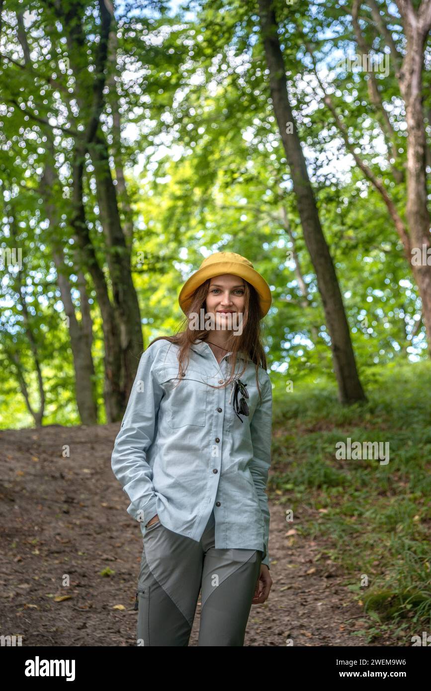 Porträt Junge Frau, die im tiefen grünen Wald spaziert. Stockfoto