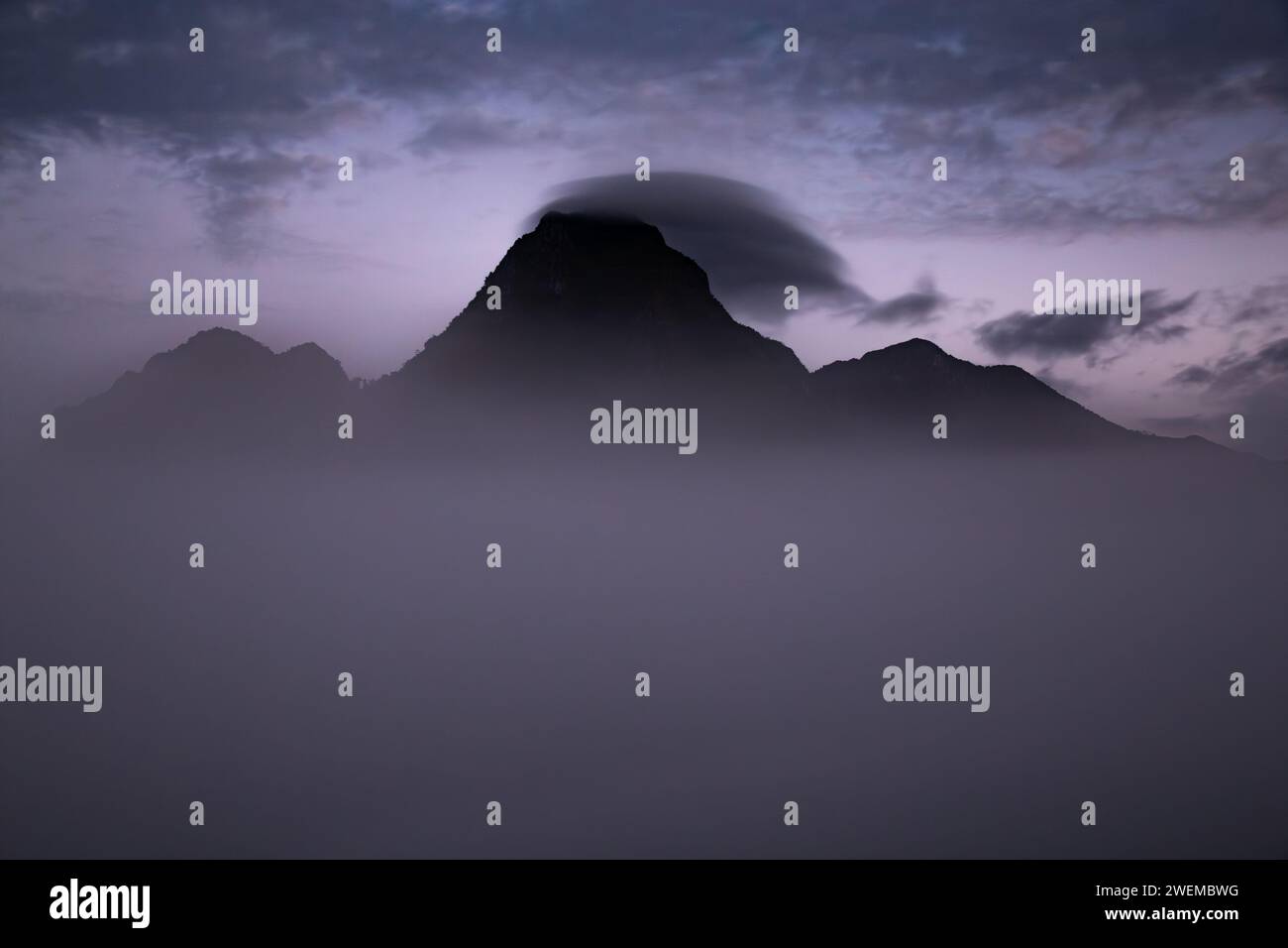 Gipfel des Berges mit Wolken unter der Dämmerung Stockfoto