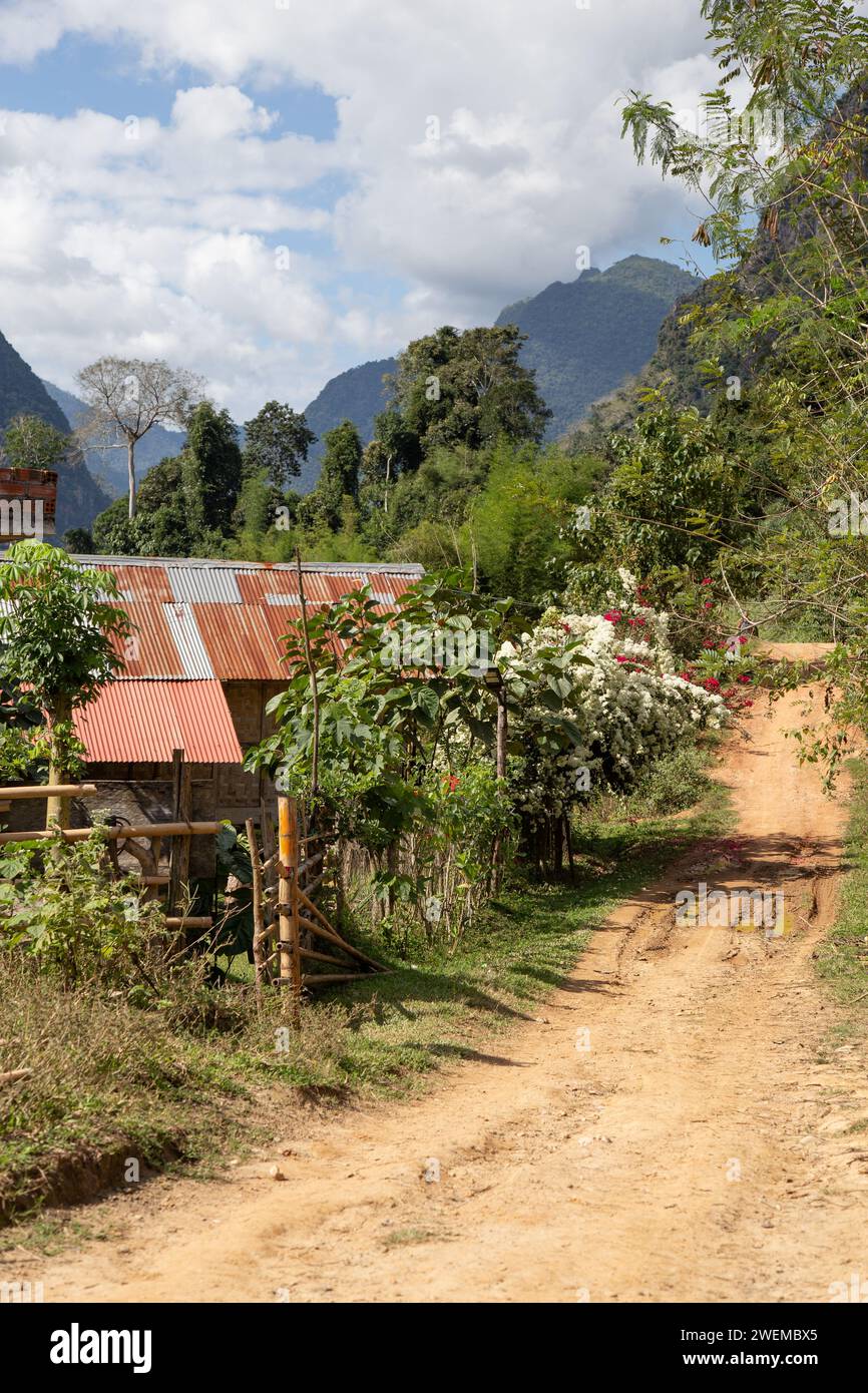 Schotterstraße neben einem Haus mit niedrigem Einkommen in Nordlaos Stockfoto