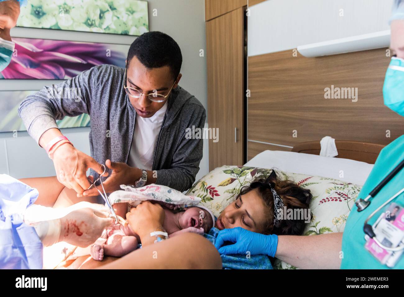 Afroamerikaner schneidet die Nabelschnur des Neugeborenen nach der Geburt Stockfoto