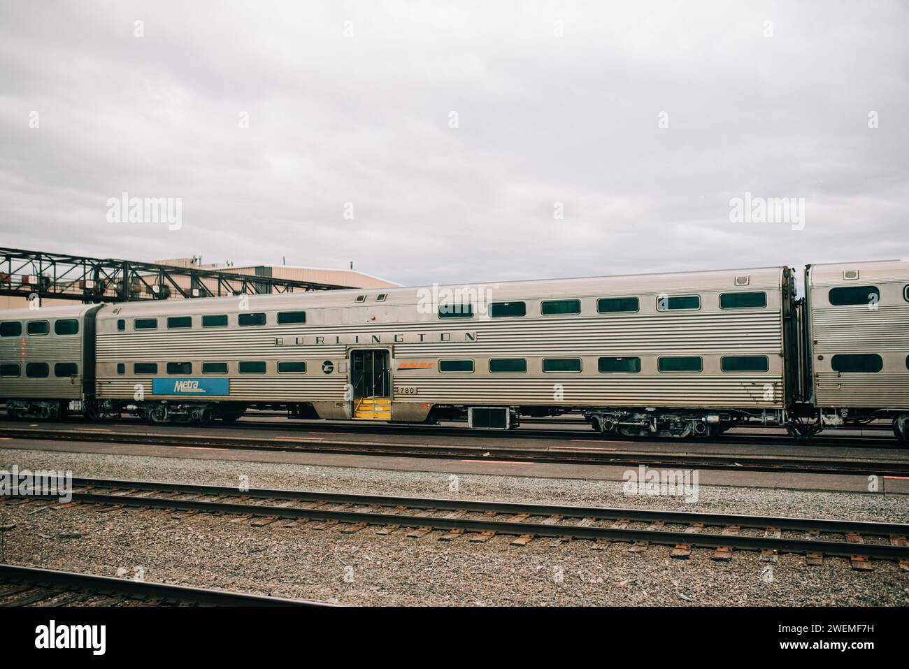 Silver Train fährt entlang der Bahngleise neben der Brücke Stockfoto