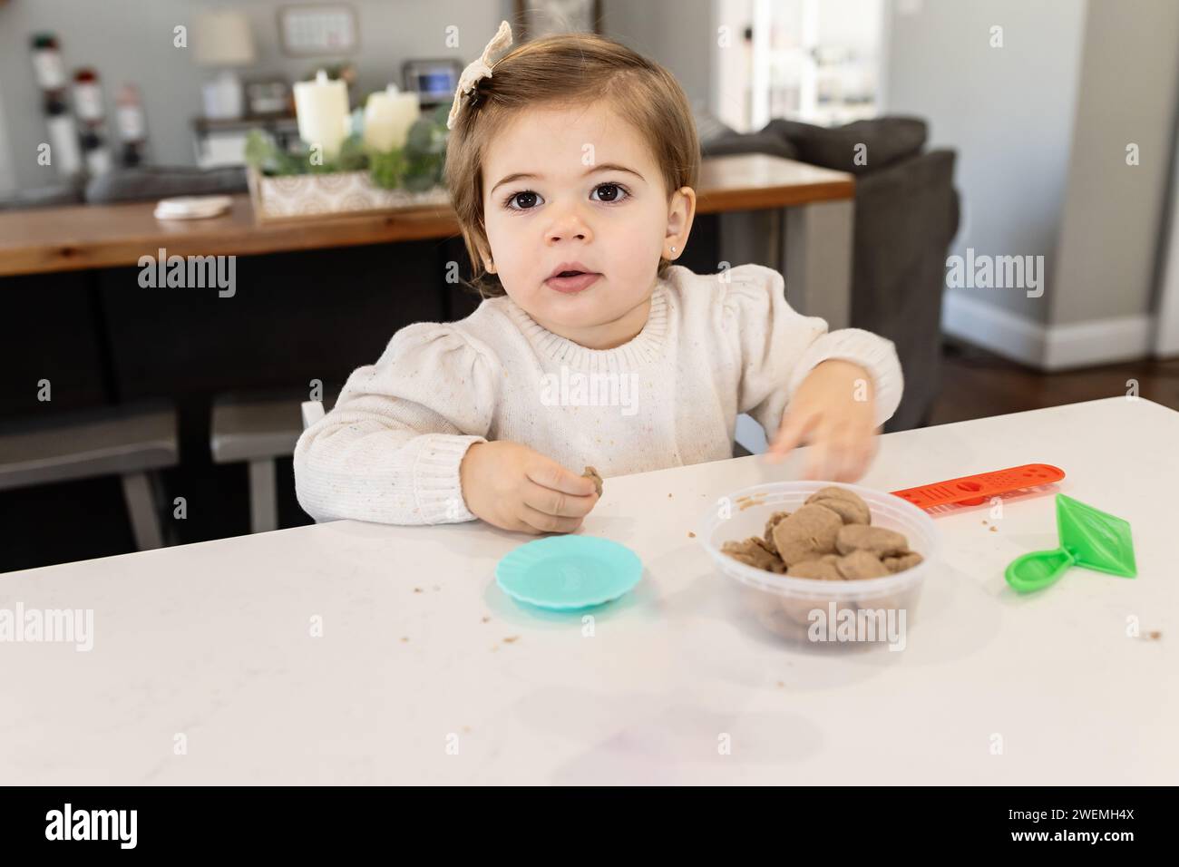 Kleinkind Mädchen spielt mit Play Dough an der Küchentheke Stockfoto