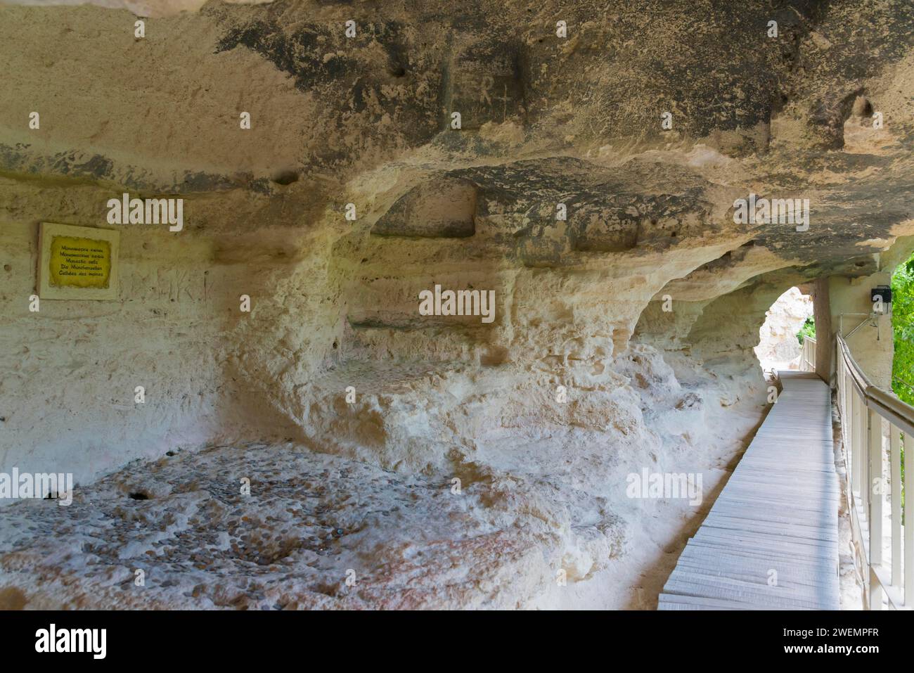 Ein Fußweg führt durch einen Höhleneingang, begleitet von Informationsschildern, Zellen der Mönche, Aladja Kloster, Aladja Kloster, Aladzha Kloster Stockfoto