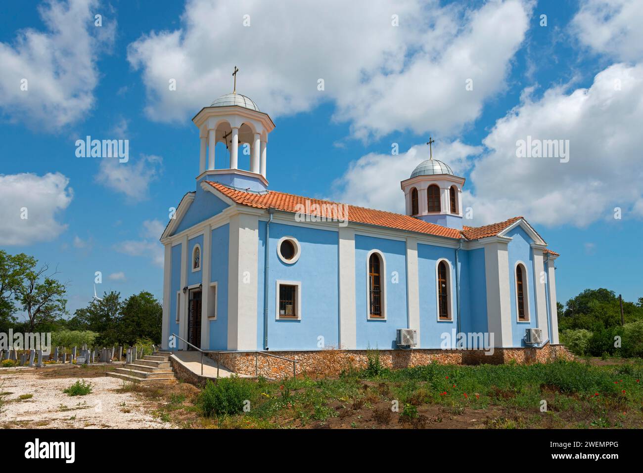 Eine kleine Kirche mit blauen Wänden und weißen Kuppeln unter einem klaren blauen Himmel umgeben von Natur, Sveti Nikola, Kavarna, Dobrich, Bulgarien Stockfoto