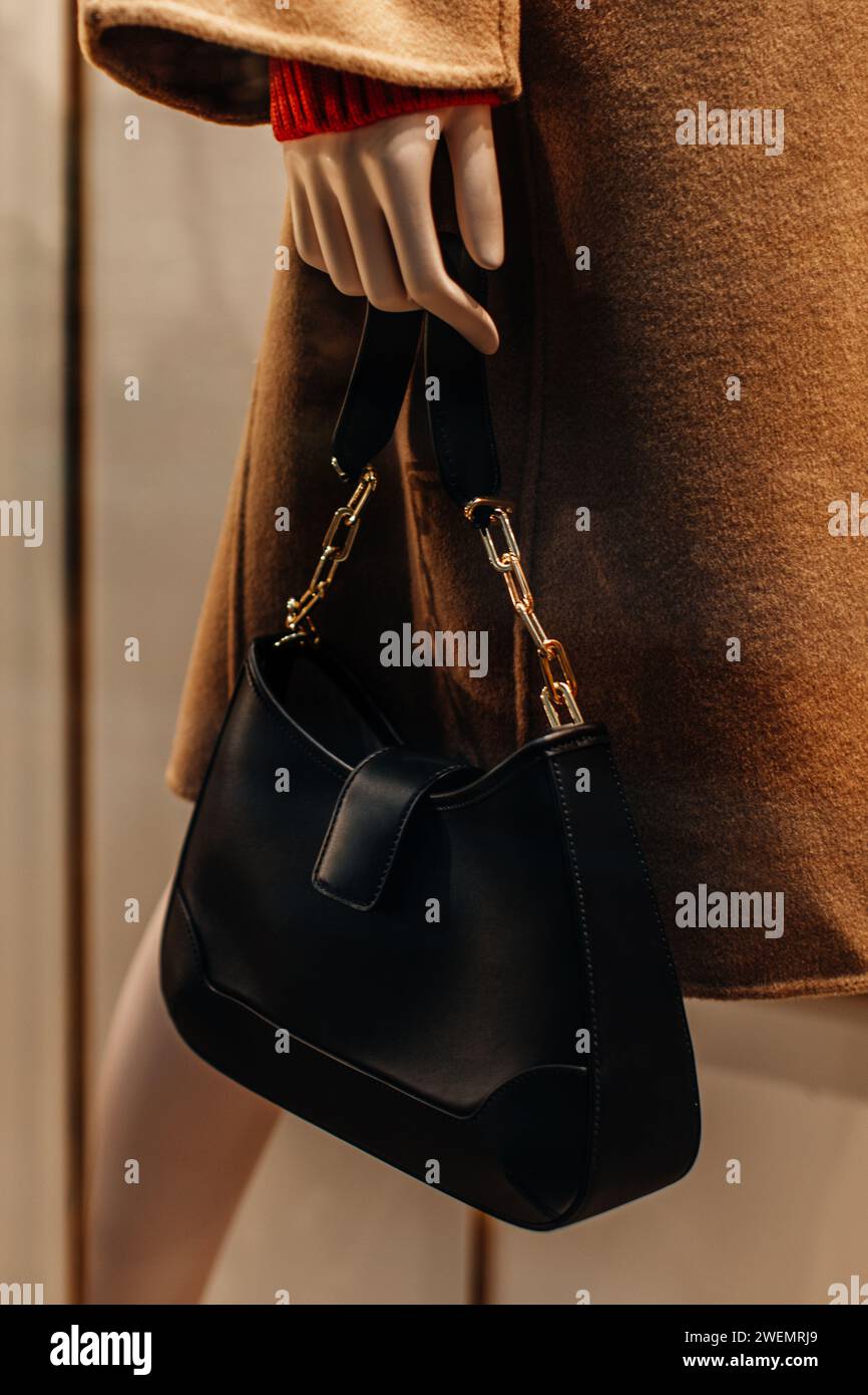 Klassische Damenhandtasche aus schwarzem Leder mit goldener Kette. Modische Details Stockfoto