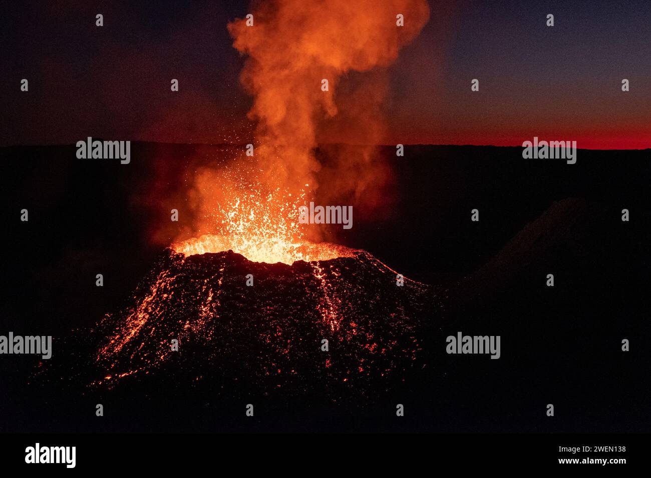 Der Vulkan Piton de la Fournaise bricht auf der Insel Reunion aus und schießt unter dem Schutz der Dunkelheit Ströme aus geschmolzener Lava hoch in die Luft. Stockfoto