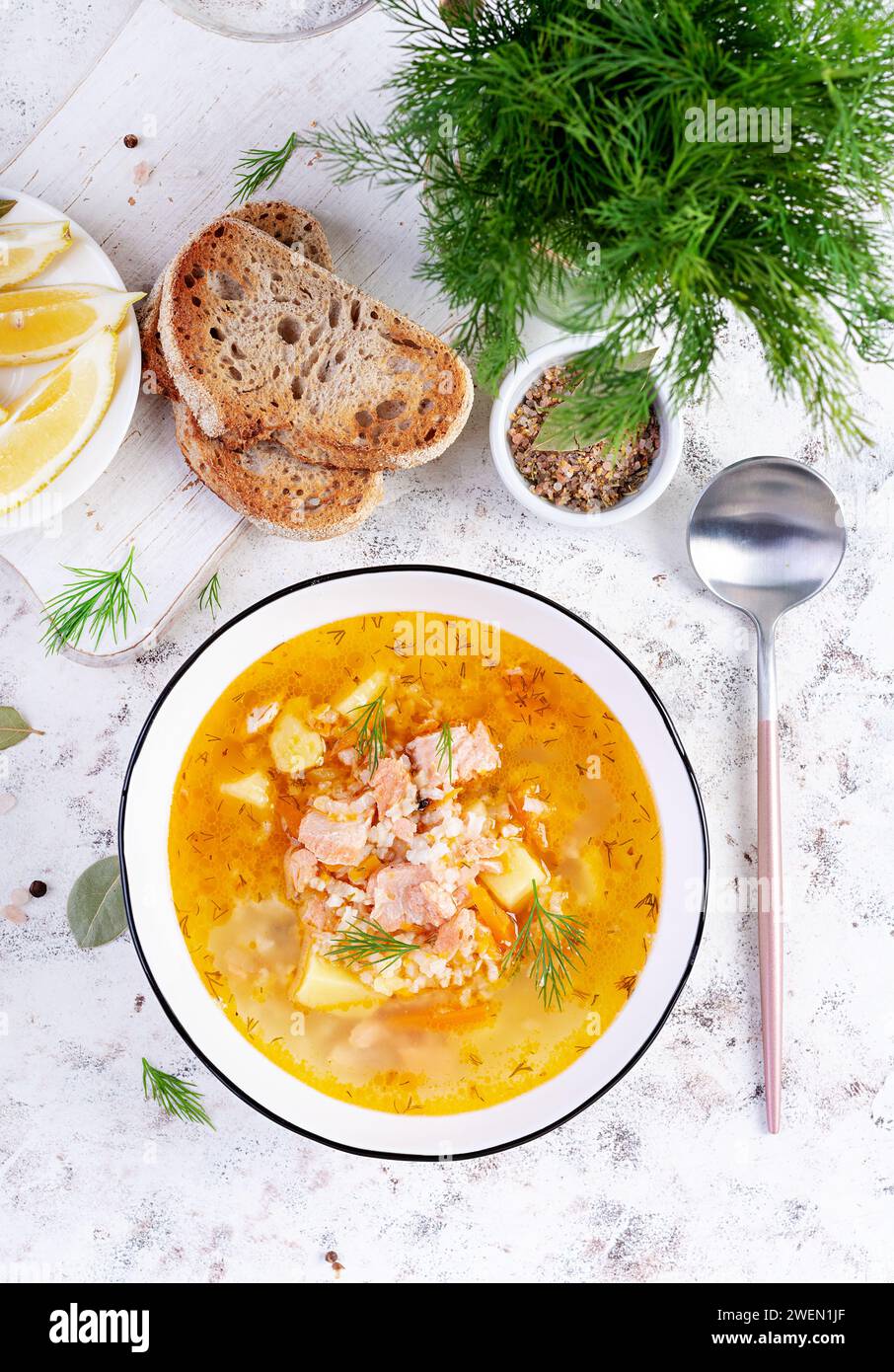 Fischsuppe mit Lachs, Gemüse und Reis in einer weißen Schüssel. Lachssuppe. Draufsicht, flach Stockfoto