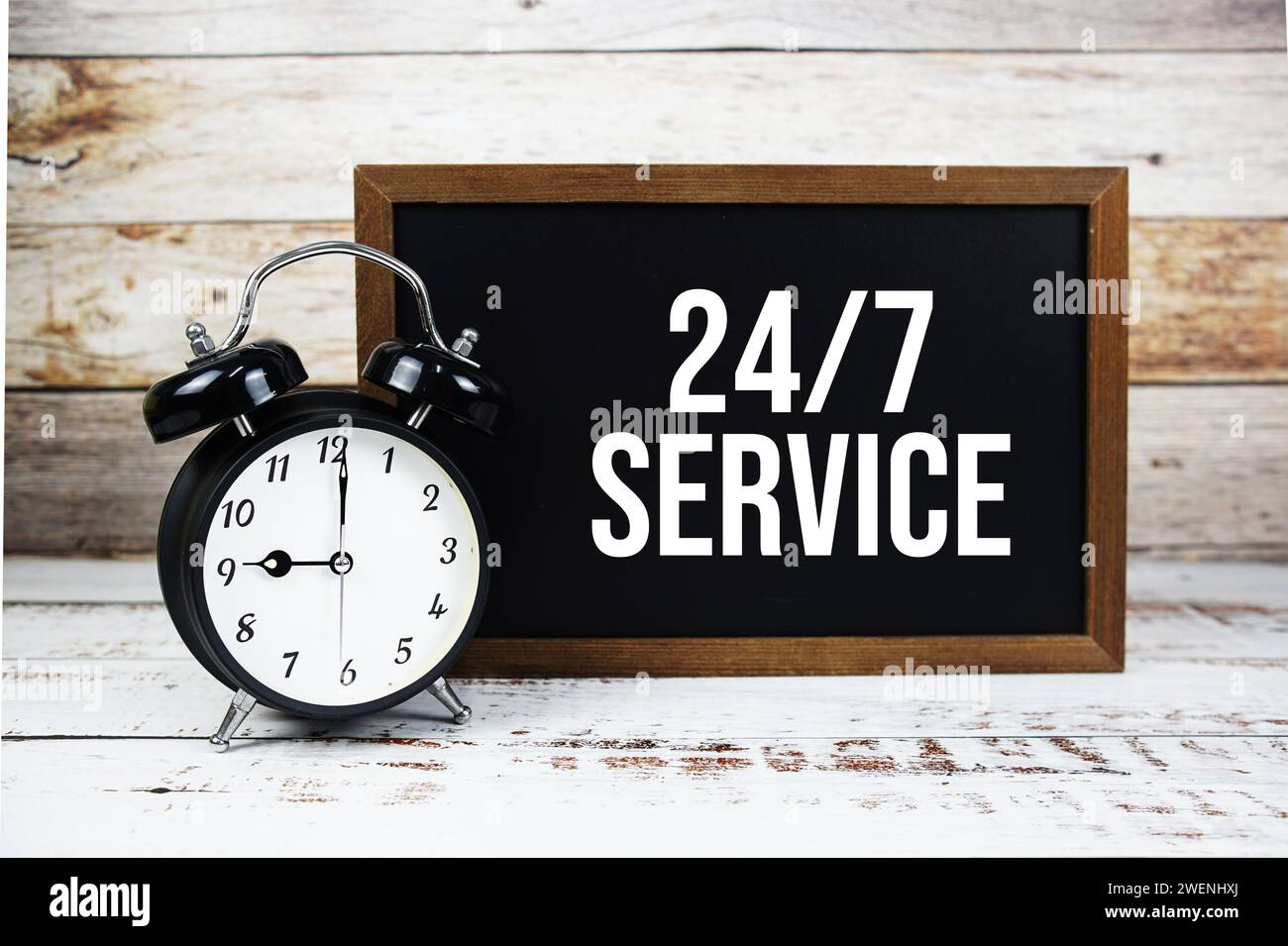 24 STUNDEN 7 TAGE Service Textnachricht und Alarmfunktion auf hölzernem Hintergrund Stockfoto