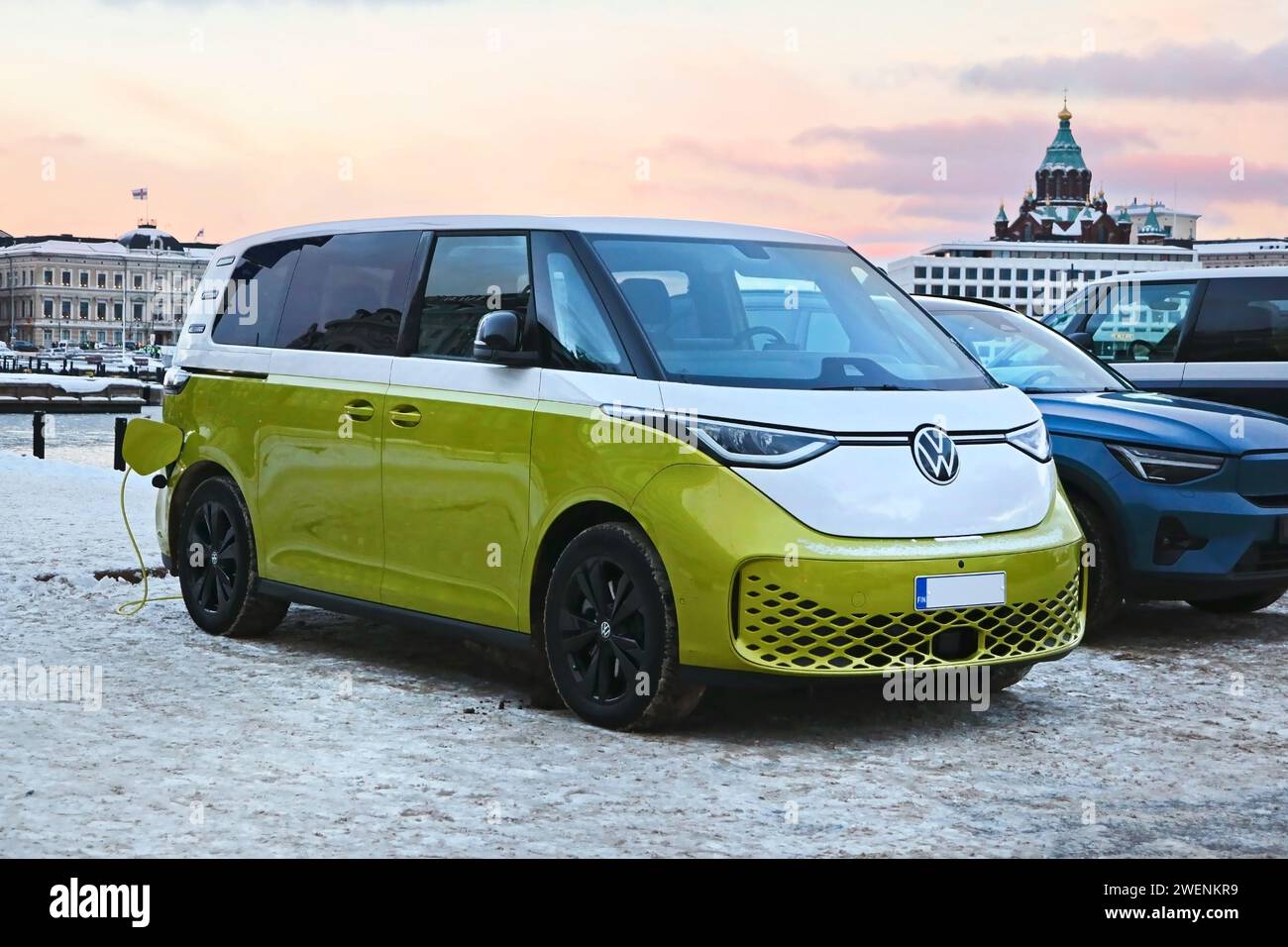 2023 Volkswagen VW ID. Buzz Elektrobus, der an einem Wintertag am öffentlichen Ladehafen am Meer die Batterie auflädt. Helsinki, Finnland. Dezember 2023. Stockfoto