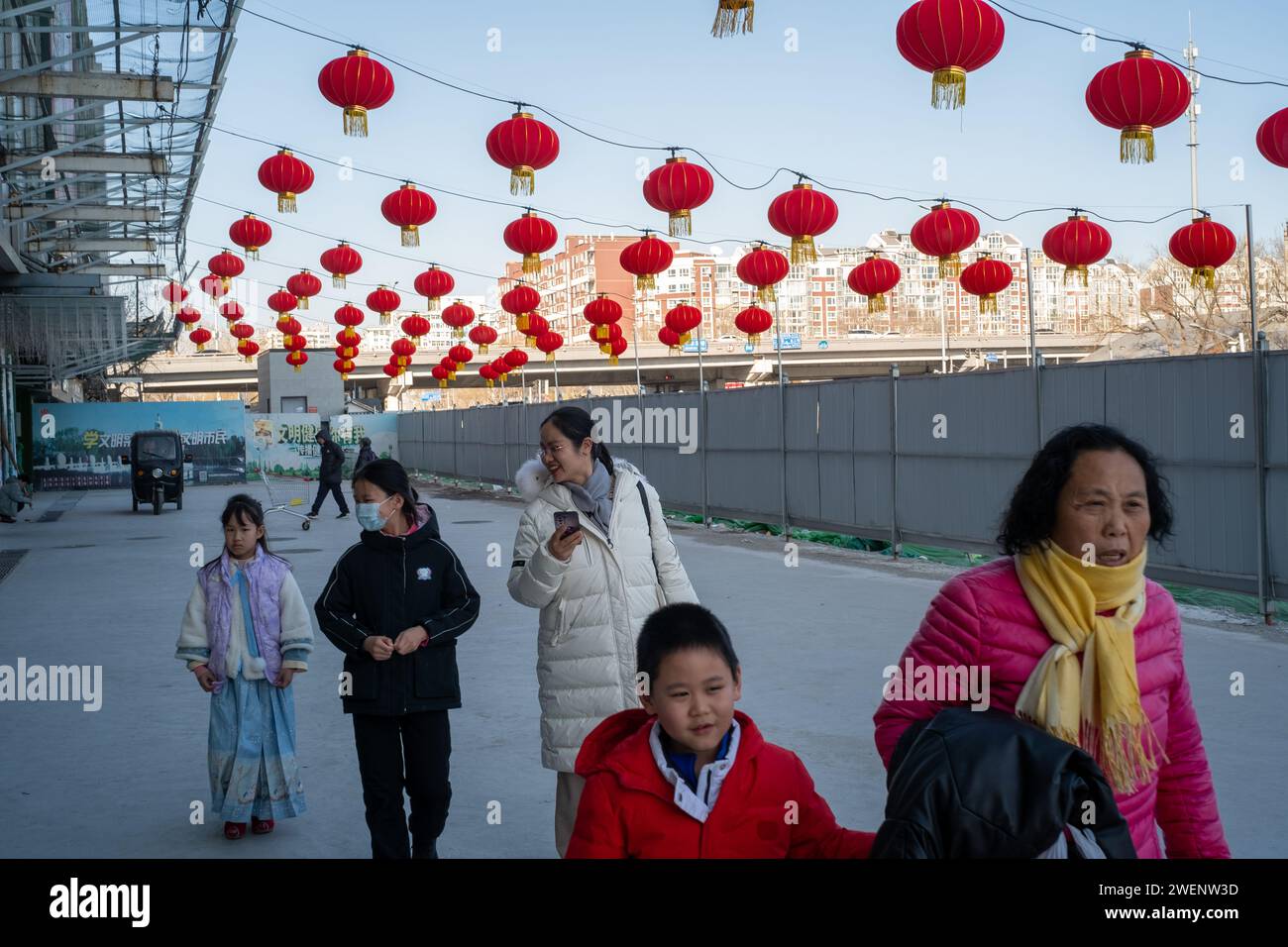 Die Verbraucher verlassen ein mit roten Laternen dekoriertes Einkaufszentrum nach dem Einkaufen, während das chinesische Frühlingsfest in Peking naht. 01-Jan-2024 Stockfoto