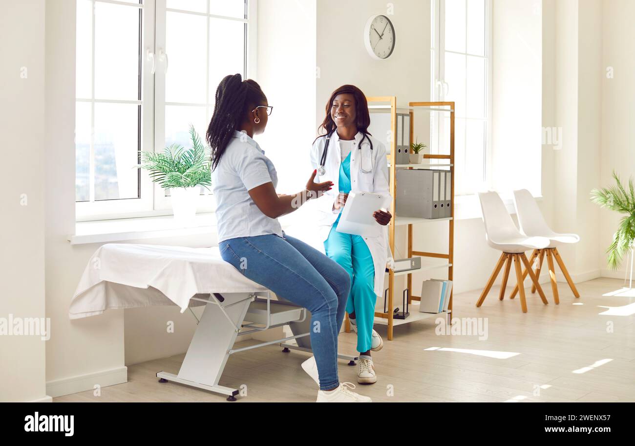 Junge afroamerikanische Ärztin und Patientin im Untersuchungsraum Stockfoto