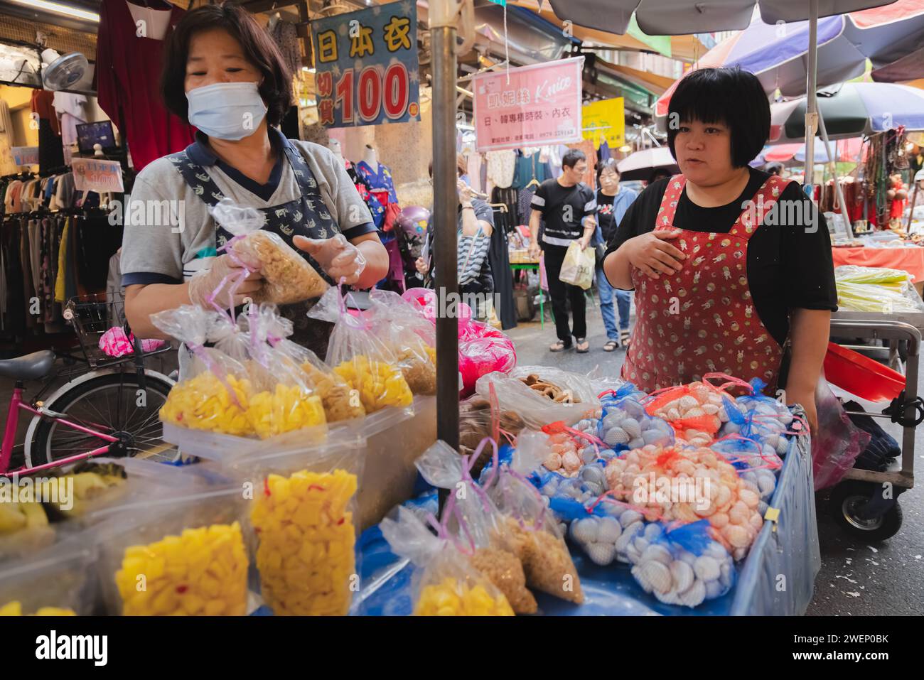 Yilan, Republik China - 2. Oktober 2023: Straßenverkäufer und Käufer auf einem farbenfrohen, geschäftigen Tagesmarkt in der Stadt Yilan, Taiwan. Stockfoto