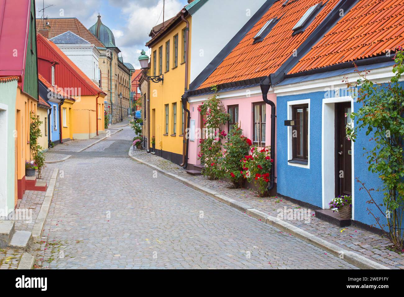 Kopfsteinpflasterstraße mit bunten Häusern in Pastellfarben in der Stadt Ystad im Sommer, Skåne / Scania, Schweden Stockfoto