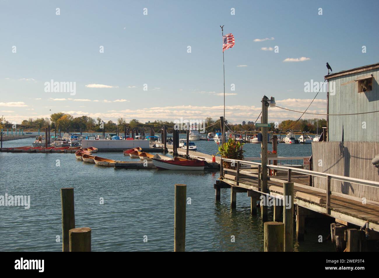 An einem sonnigen Tag in City Island, einem kleinen Wohnort an der Küste der Bronx, befindet sich ein kleiner Schuppen an einem Pier an einem Jachthafen Stockfoto