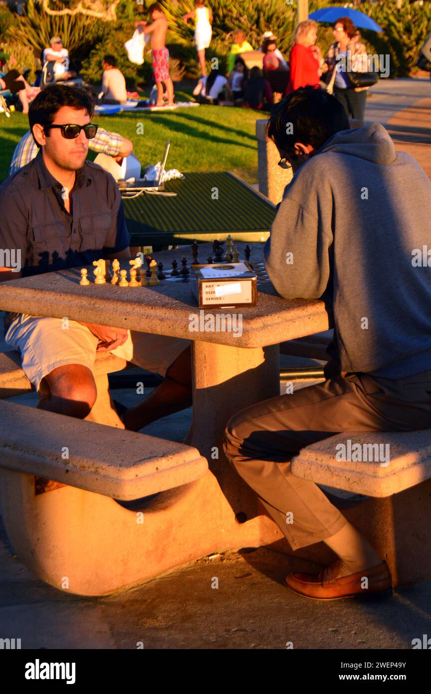 Zwei Freunde genießen ein Schachspiel an einem Tisch im Freien in einem Park nahe der Küste von Laguna Beach, Kalifornien Stockfoto