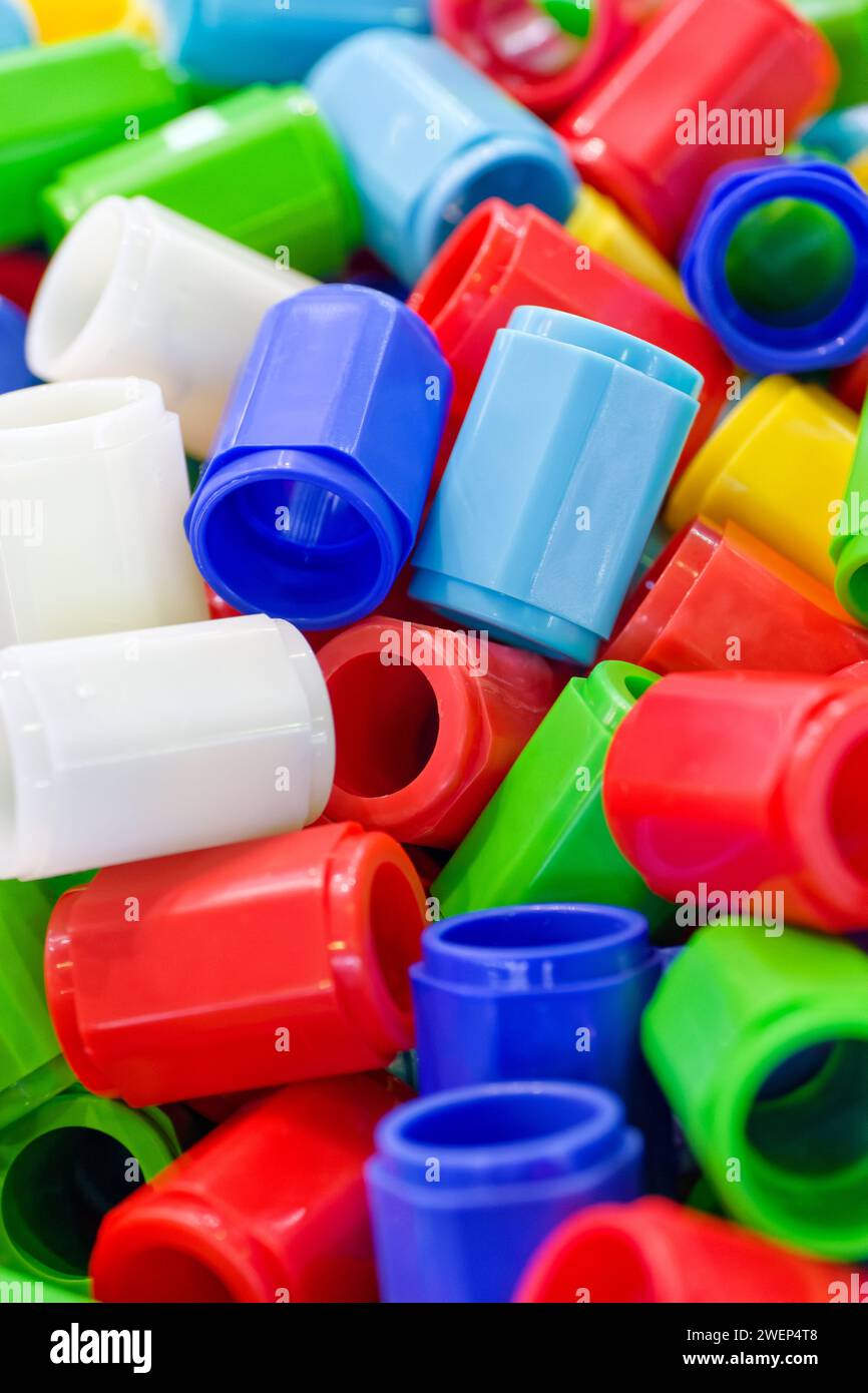 Großes Sortiment an mehrfarbigen Kunststoffteilen, abstrakte industrielle Produktion oder Recycling-Hintergrund Stockfoto