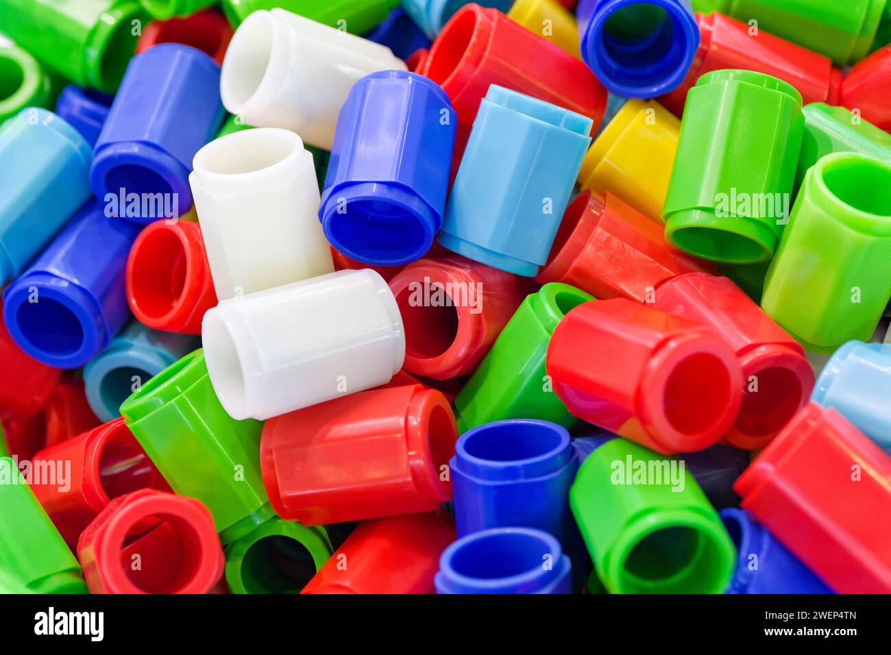 Großes Sortiment an mehrfarbigen Kunststoffteilen, abstrakte industrielle Produktion oder Recycling-Hintergrund Stockfoto