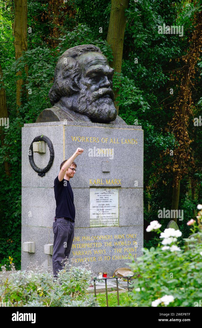 London: Am Grab von Karl Marx. - Ein junger Mann steht auf dem Highgate-Friedhof in London mit erhobener Faust neben der gepflegten Grabstätte von Kar Stockfoto
