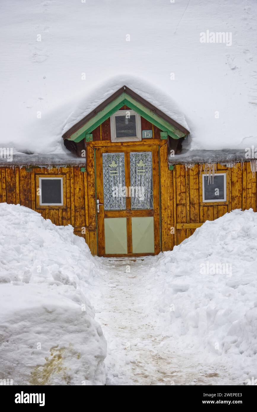 Hölzerne Hütte aus dem Anfang des 20. Jahrhunderts mit einer dicken Schneeschicht bedeckt. Stockfoto