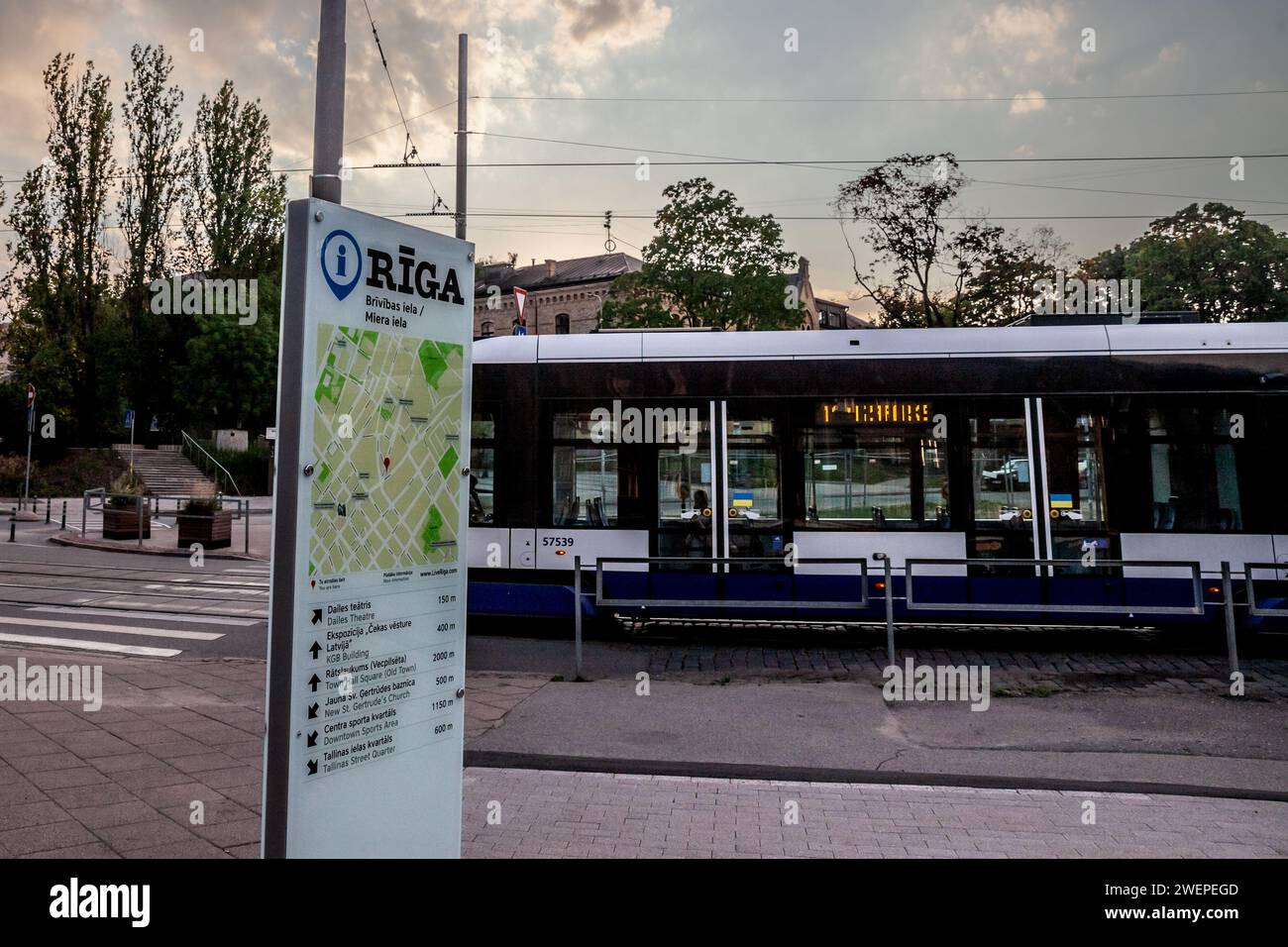 Bild einer Straßenbahn, die in den Straßen von riga fährt, betrieben von Rigas satiksme vor einer Karte von riga. Rīgas satiksme ist ein öffentliches Unternehmen in kommunalem Besitz Stockfoto