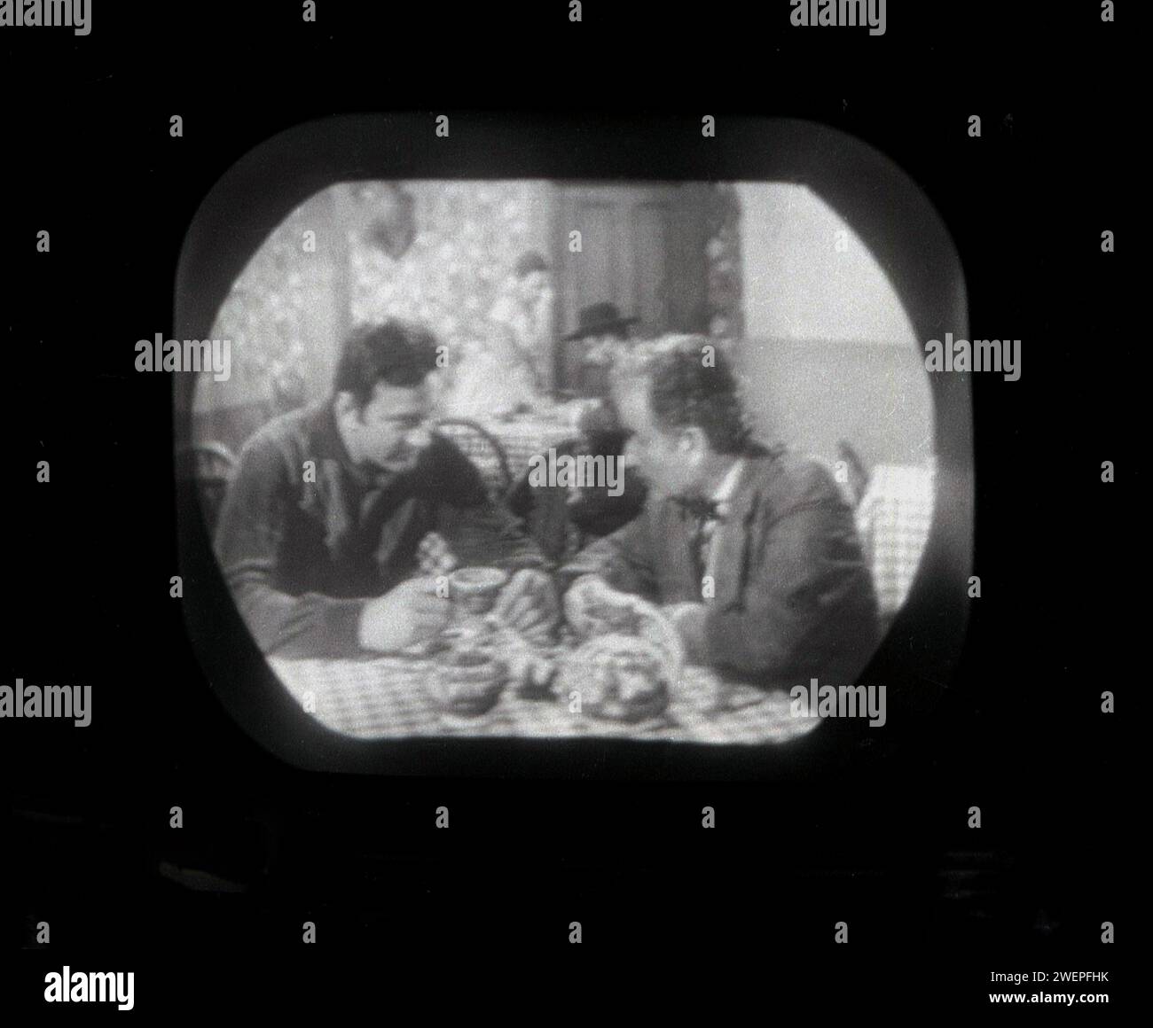 1960er Jahre, historisch, auf einem kleinen Bildschirm eines Fernsehers der Ära, die Fernsehserie Bonanza wird ausgestrahlt, zwei männliche Charaktere sitzen an einem Tisch. Die US-amerikanische Western-tv-Serie war mit 431 Episoden von 1959 bis 1973 sehr beliebt. Stockfoto
