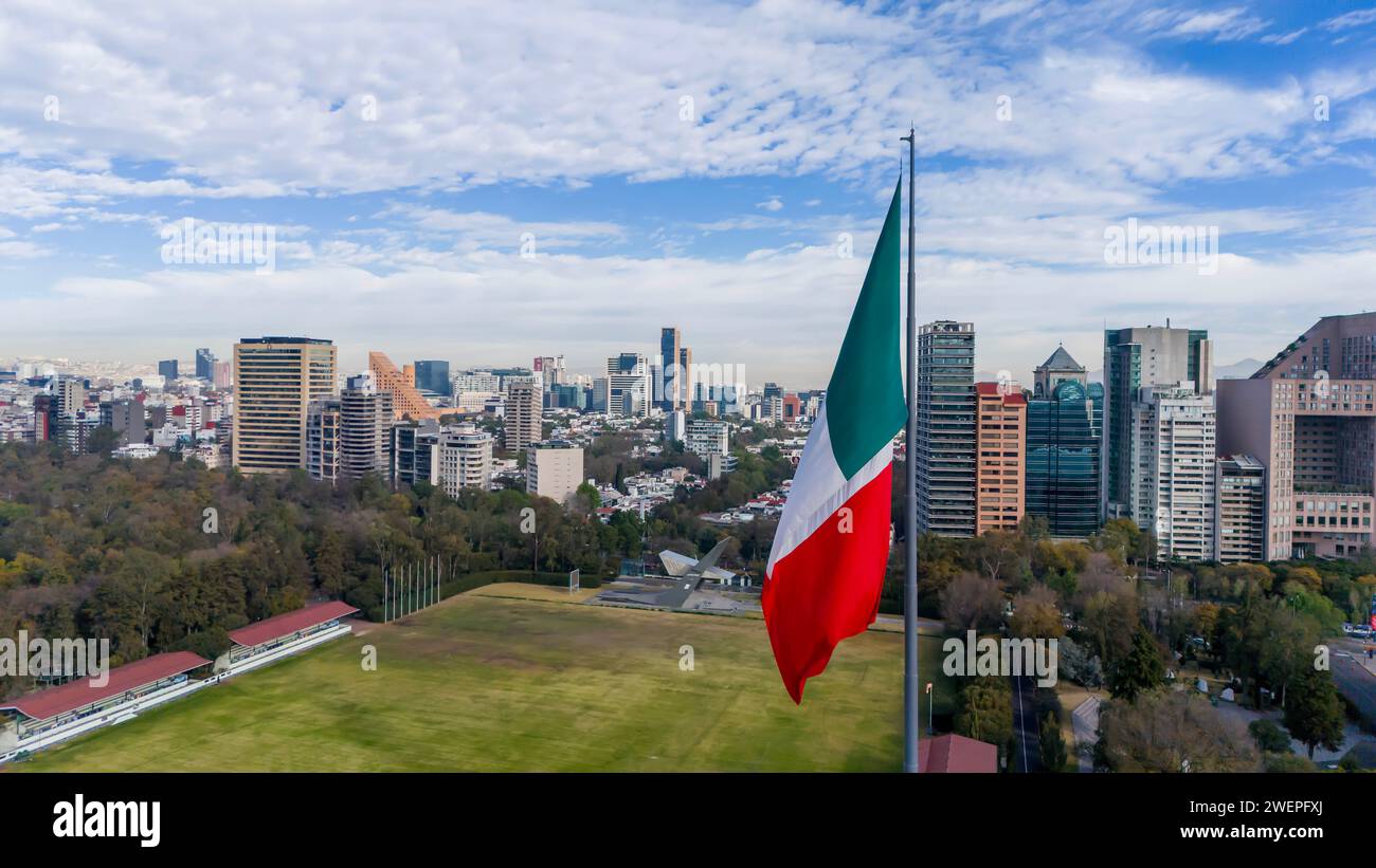 Ciudad de Mexico, Yucatan, USA. Januar 2024. In Mexiko-Stadt weht die riesige mexikanische Nationalflagge stolz vor dem Stadtbild und der bergigen Kulisse, die von der sanften Brise (Credit Image: © Walter G Arce SR Grindstone Medi/ASP) NUR REDAKTIONELLE VERWENDUNG geweckt wird! Nicht für kommerzielle ZWECKE! Stockfoto